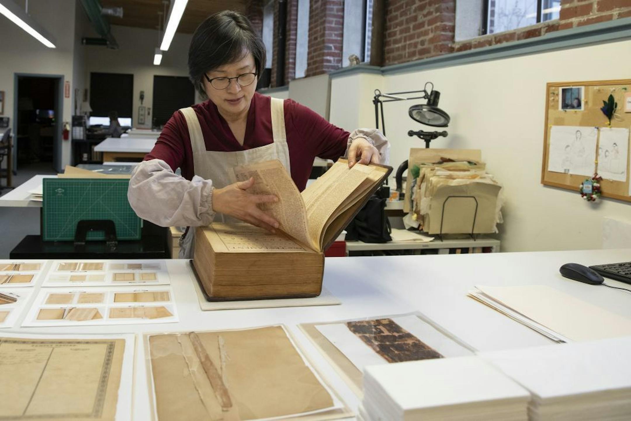 Jungohk (Theresa) Cho, who restored Betsy Ross's family Bible, flips through its pages in the lab at the Conservation Center for Arts and Historic Artifacts in the Rittenhouse neighborhood of Philadelphia on Tuesday, Feb. 12, 2019.