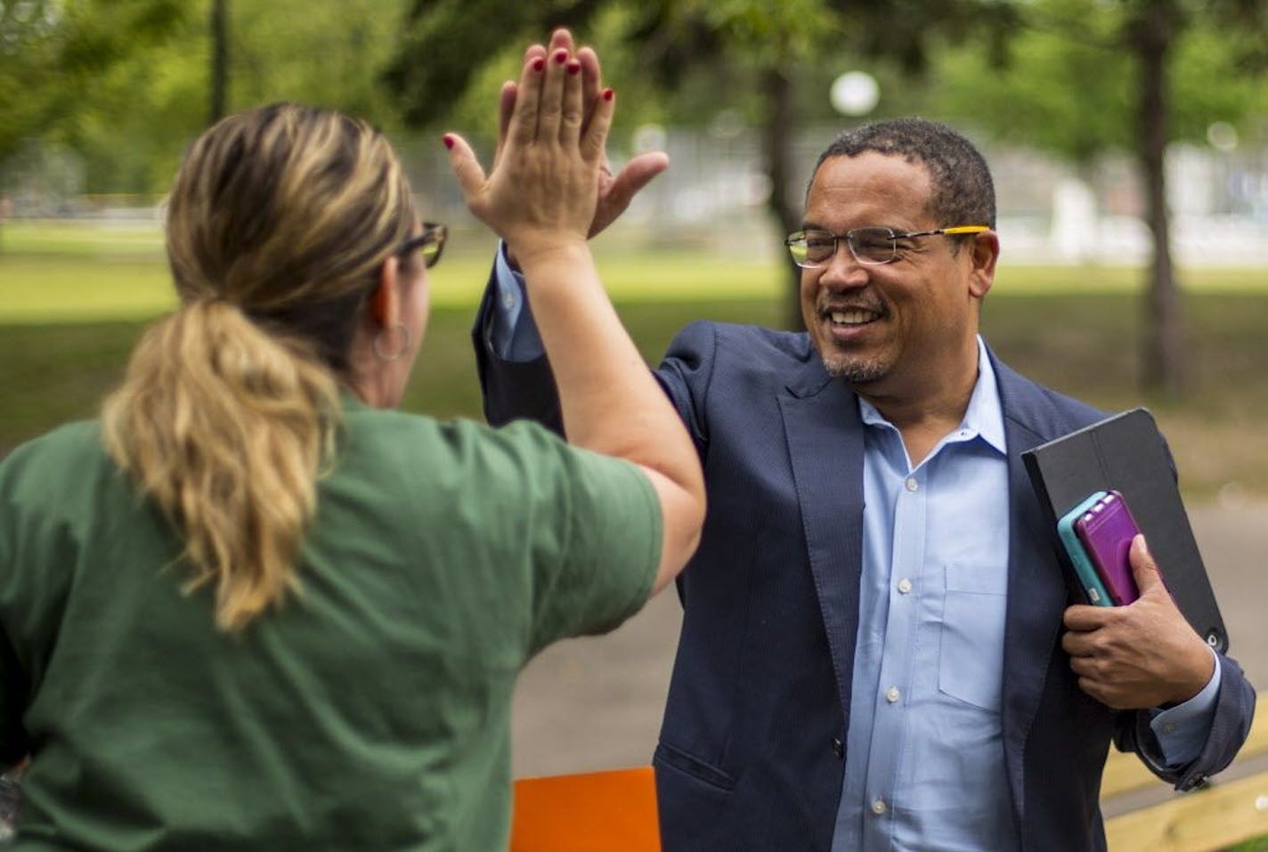 U.S. Rep. Keith Ellison high fives one of his campaign volunteers at a door-knocking event in north Minneapolis.