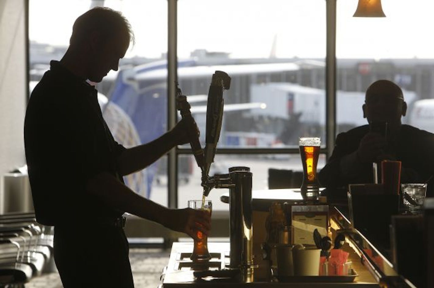 The Airport Bar/restaurants go for a better product and service for the traveler. D'amico's &Sons Bartender, Graham Cairns pulls a tall beer at O'Gara's Bar and Grill St. Paul, MSP airport