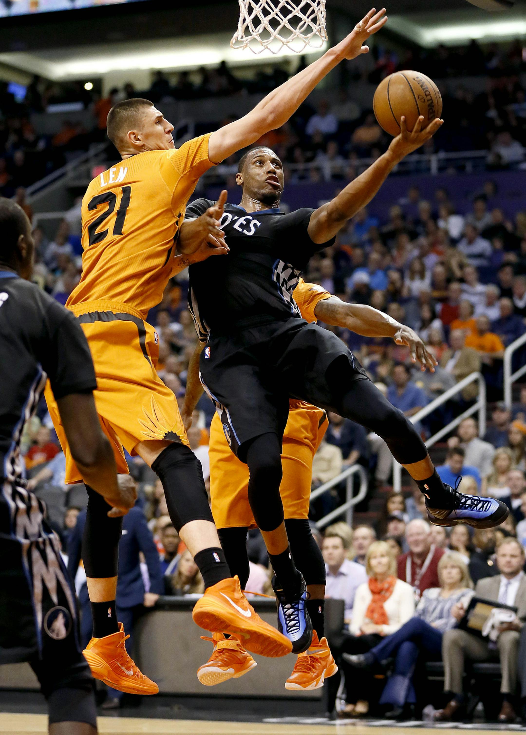Minnesota Timberwolves' Thaddeus Young, front right, shoots over Phoenix Suns' Alex Len during the first half of an NBA basketball game, Friday, Jan. 16, 2015, in Phoenix. (AP Photo/Matt York)