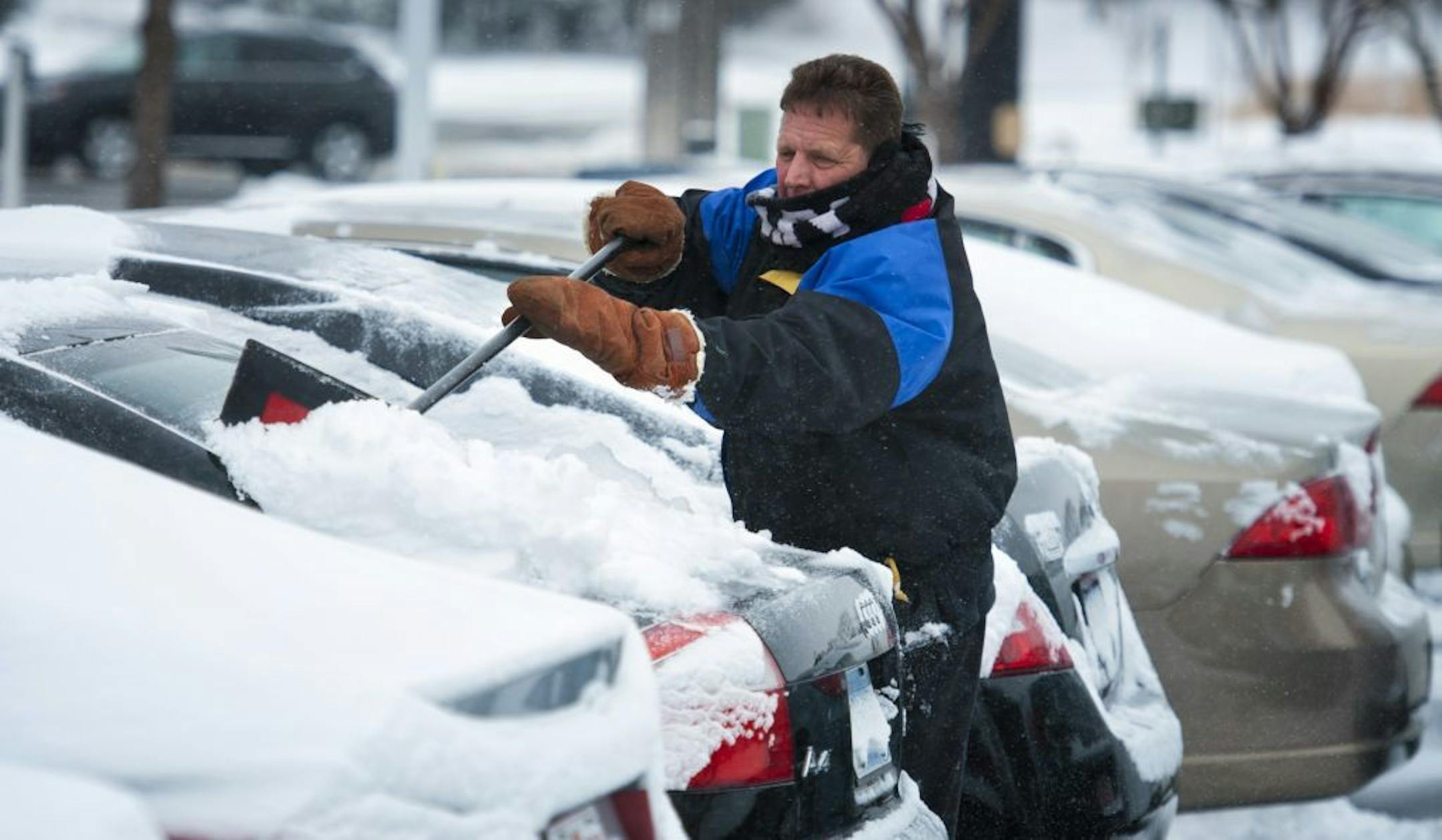 Gene Fritz cleared snow from new vehicles at Valley Buick in Apple Valley Thursday morning. The south suburbs received a couple of inches of snow while areas farther south were hammered with up to 16 inches. Thursday, December 20, 2012