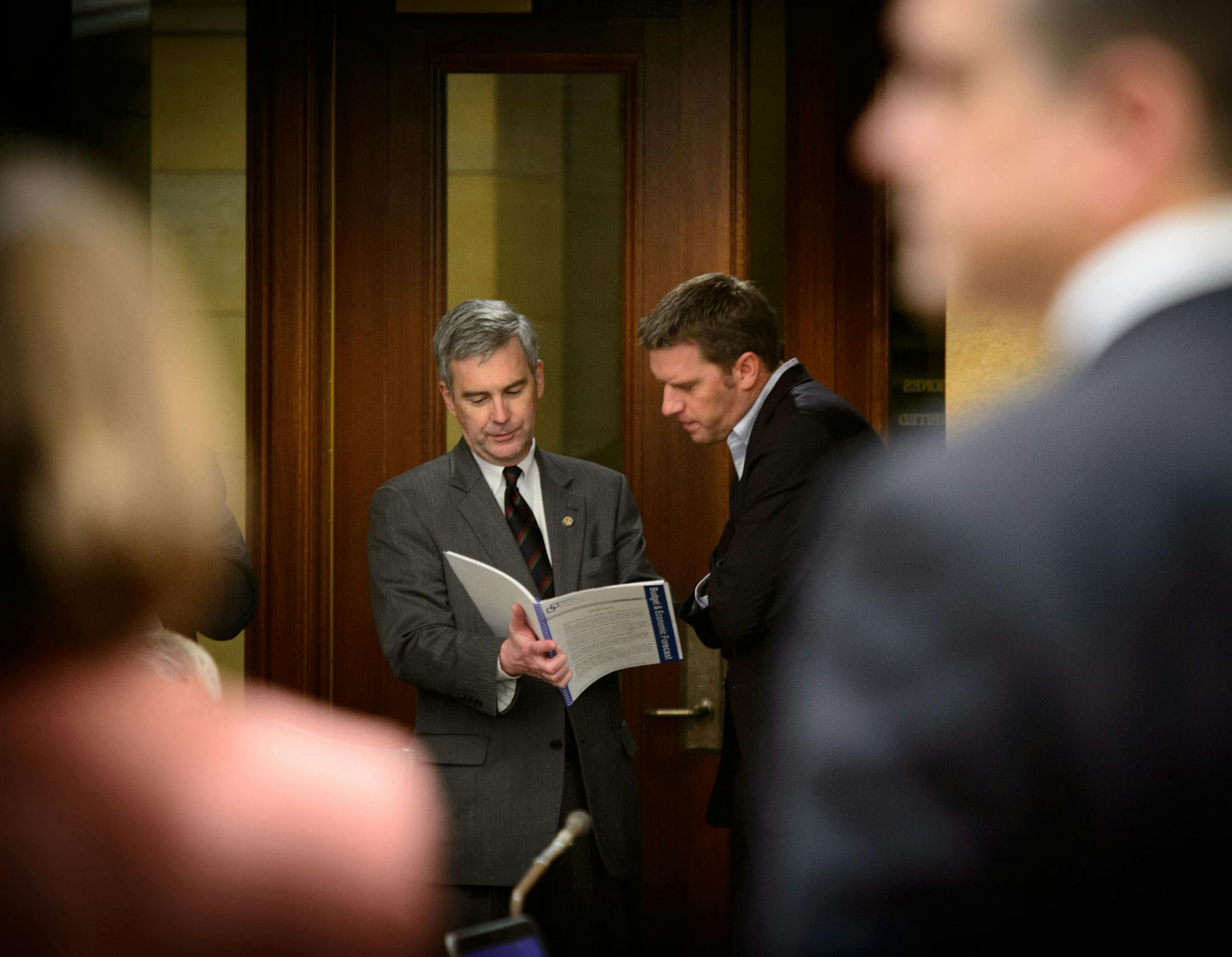 Republican leaders, Senate Minority Leader David Hann of Eden Prairie and House Minority Leader Kurt Daudt of Crown, looked over the budget numbers before their rebuttal presentation. The surplus “should be back in the economy,” Hann said. Daudt and other Republicans said the surplus proves DFLers raised too much in taxes.