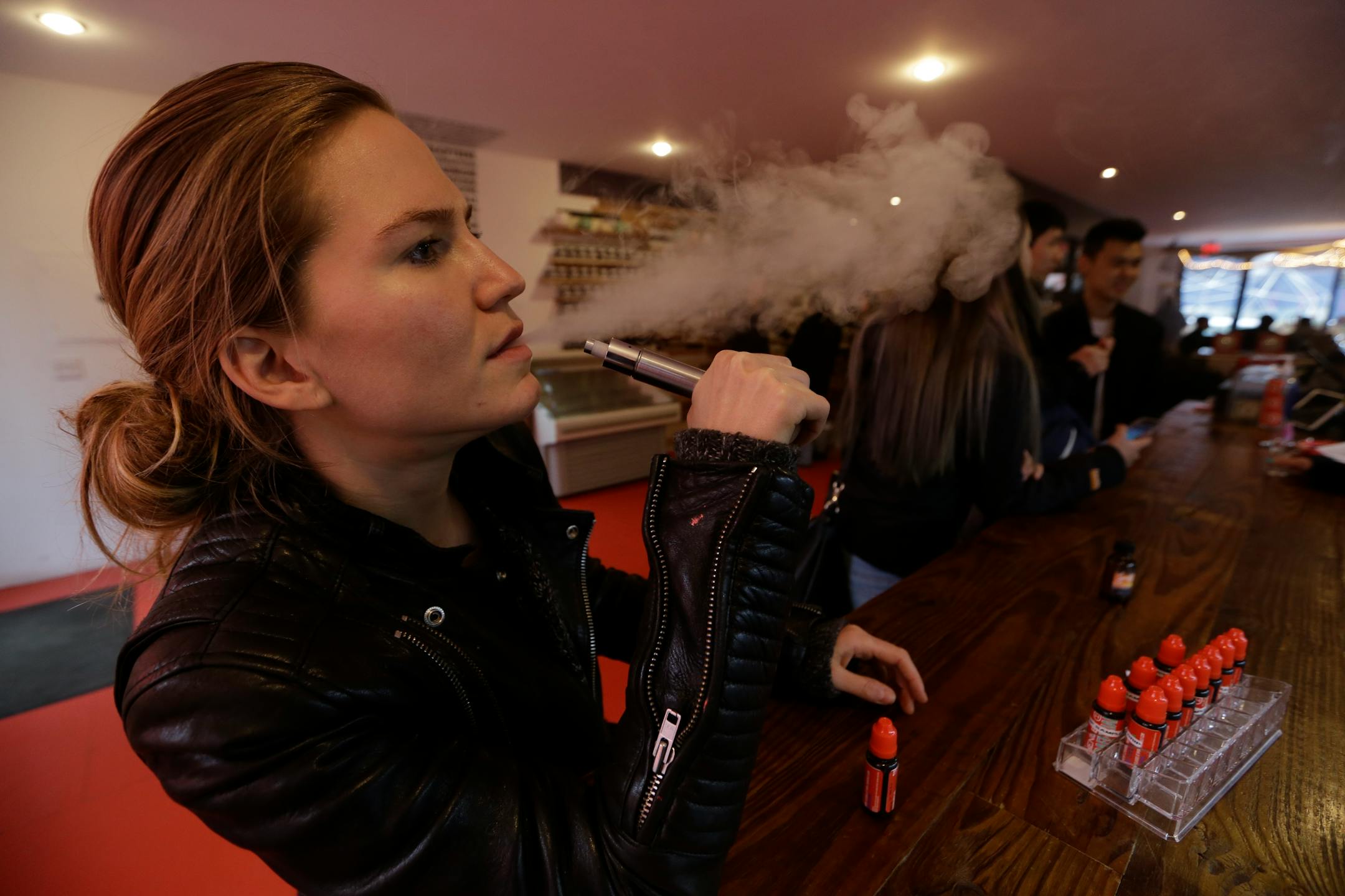 Feb. 20, 2014: Talia Eisenberg, co-founder of the Henley Vaporium, uses her vaping device in New York. The vaporium is an intimate hipster hangout in the Soho neighborhood with overstuffed chairs, exposed brick, friendly counter help, but no booze. Instead, the proprietors are peddling e-cigarettes, along with bottles of liquid nicotine ready to be plucked from behind a wooden bar and turned into flavorful vapor for a lung hit with a kick that is intended to simulate traditional smoking.