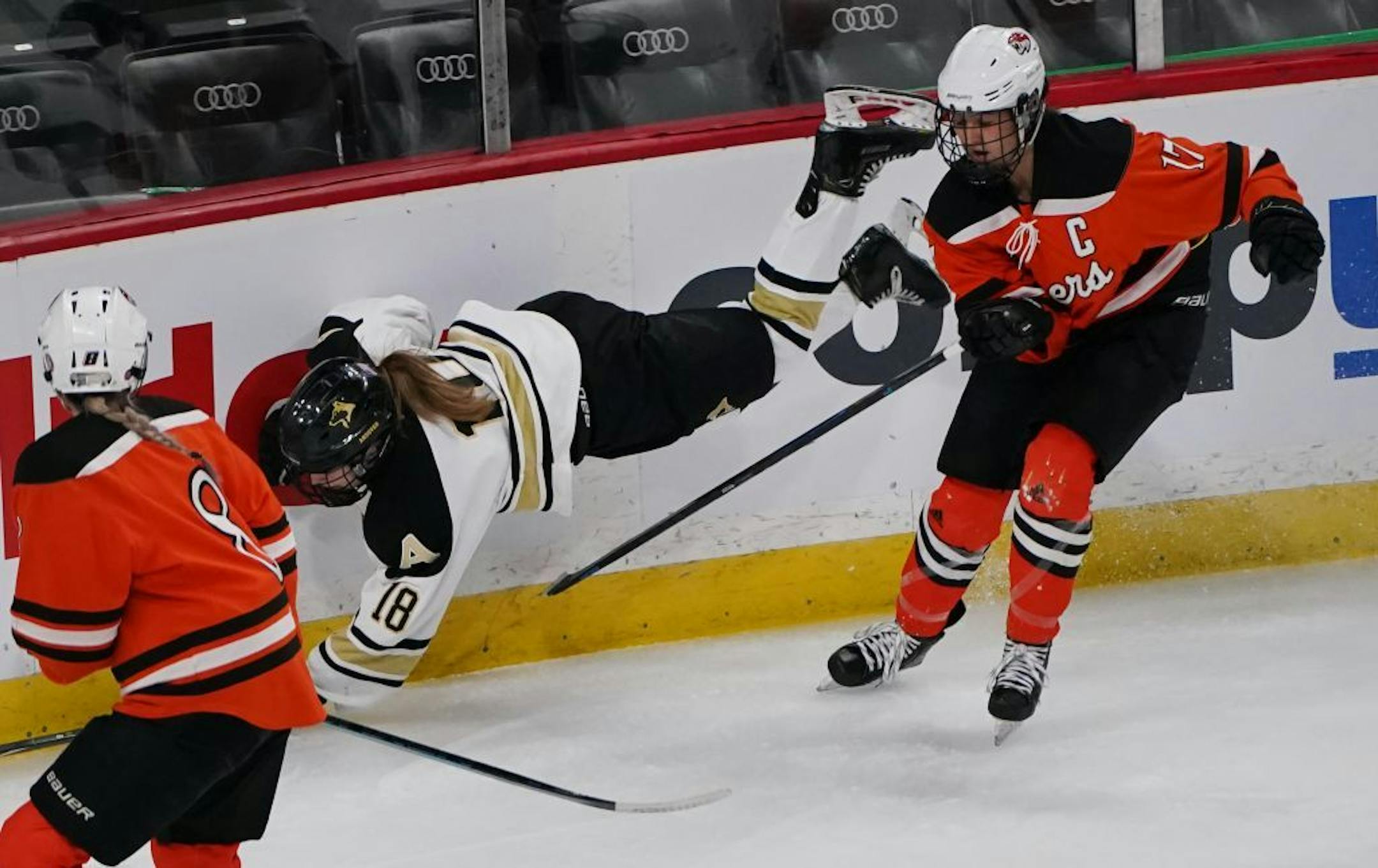 Andover forward Gabby Krause (18) was upended while battling along the boards with Farmington defenseman Brenna Fuhrman (17) in the first period of their quarterfinal game Friday.