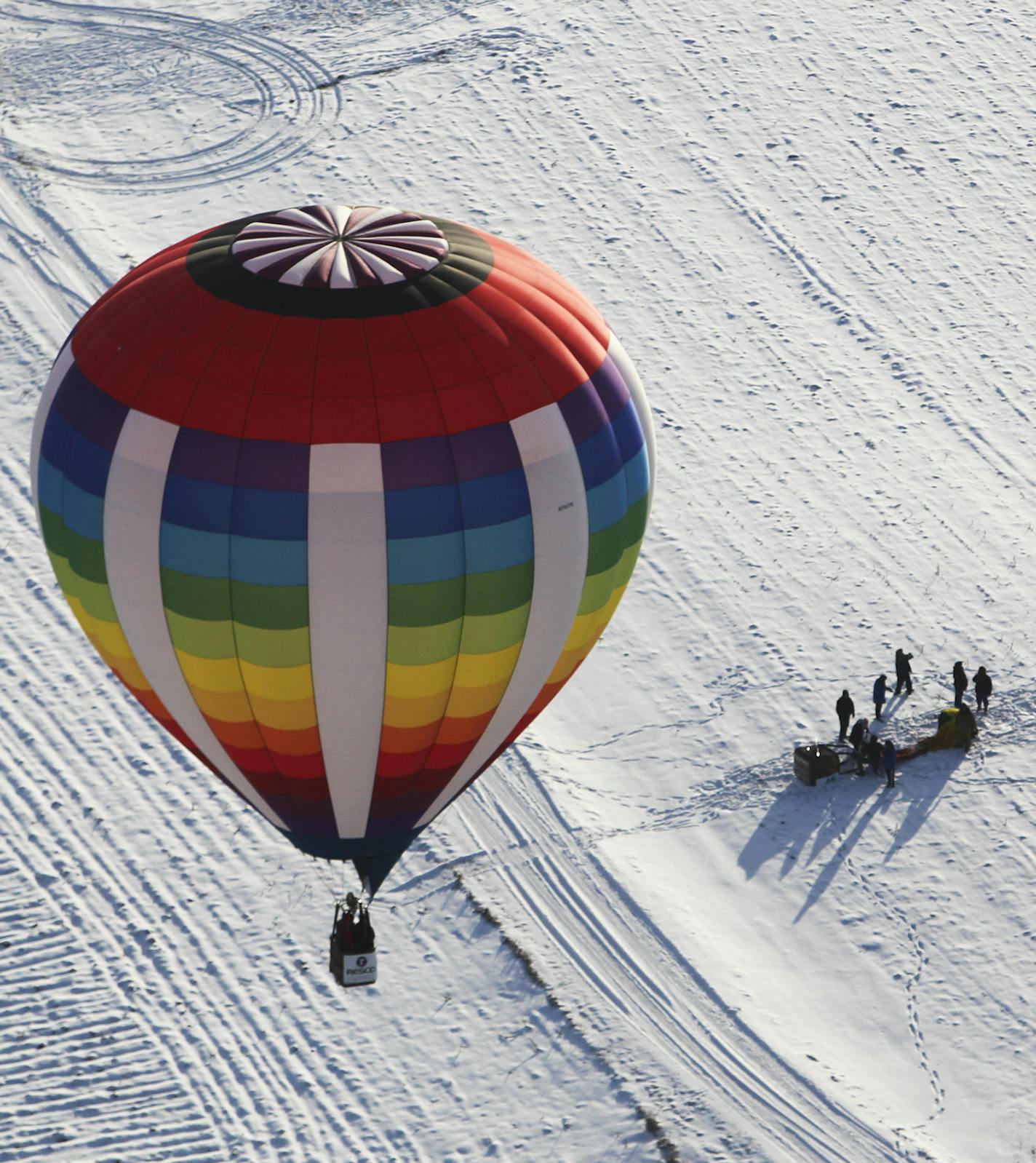 After launching from E. P. Rock School, a balloon drifts to near its landing as the chase crew of another balloon pack it up a few miles south of the launch during the Hudson Hot Air Affair Saturday, Feb. 2, 2013, in Hudson, WI.] (DAVID JOLES/STARTRIBUNE) djoles@startribune.com Billed as one of the Midwest' premier winter ballooning events, the 24th annual Hudson Hot Air Affair took place Saturday morning in near sub-zero weather but with crisp skies and low winds and featured dozens of balloons