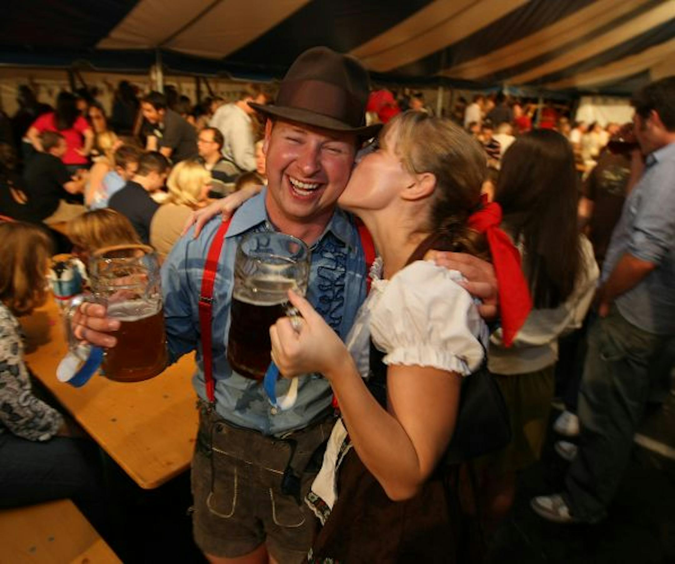 Kirsten Lamoureaux puts a big kiss on her partner, Jeff Wallace, as she swings her beer Saturday night at Gasthof's.