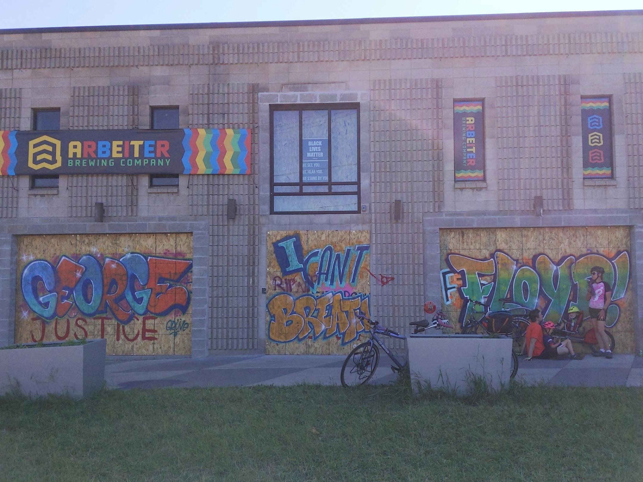 A series of George Floyd-inspired graffiti cover the boarded-up windows of Arbeiter Brewing Company at 3036 Minnehaha Ave. across the street from the U.S. Post Office on 27th Ave. that was destroyed by fire.