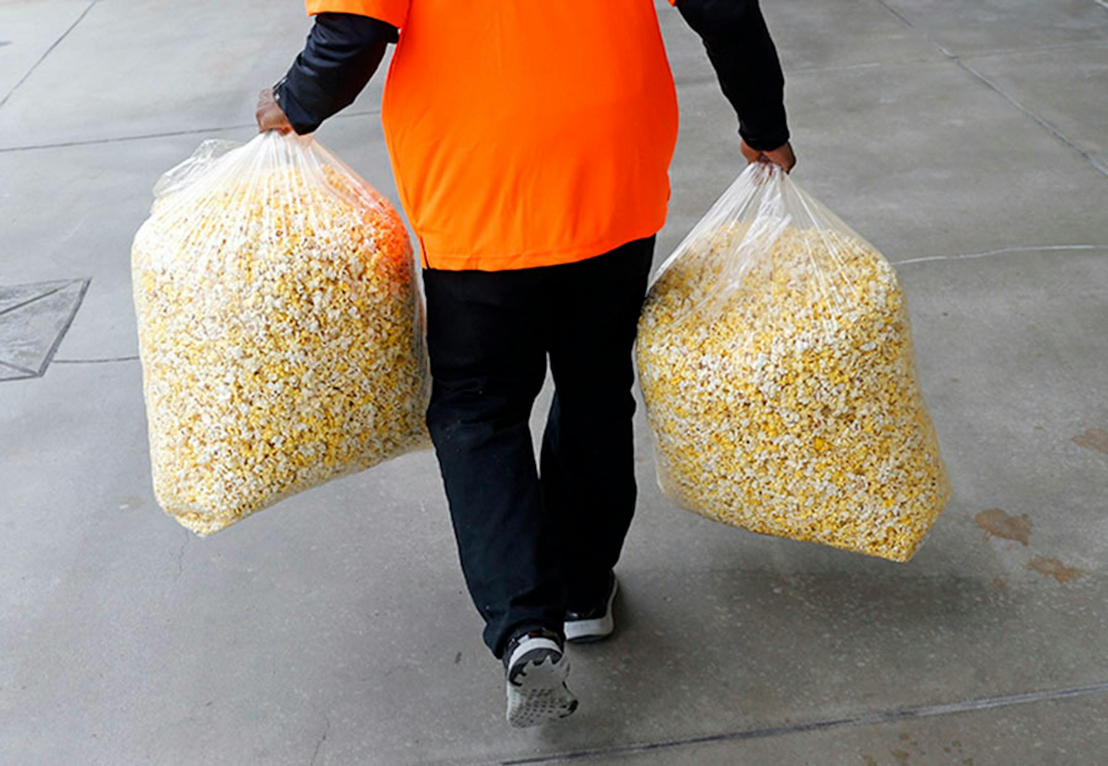 A vendor carries bags of popcorn before an opening day baseball game between the Baltimore Orioles and the Minnesota Twins in Baltimore, Monday, April 4, 2016. (AP Photo/Patrick Semansky)