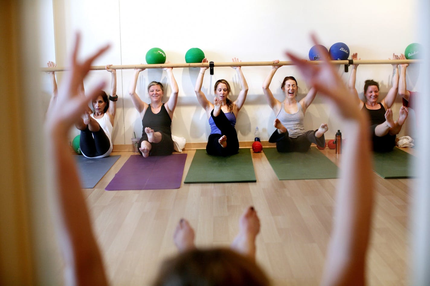 Co-owner Emily Easton, far right, and studio manager Danielle DeRemer, second from right, share a laugh during the Align Barre Class at Align Pilates in Uptown December 7, 2011.