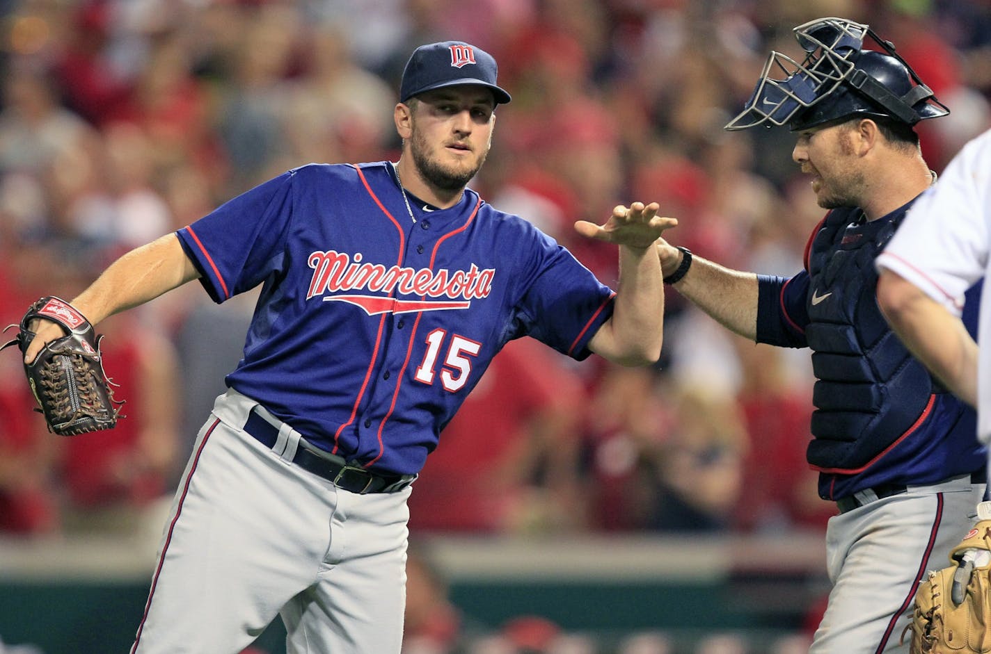 Minnesota Twins catcher Ryan Doumit congratulates relief pitcher Glen Perkins (15) after theTwins defeated the Cincinnati Reds 5-4 in a baseball game, Friday, June 22, 2012, in Cincinnati. Doumit hit a home run and Perkins recorded his second save in the game.