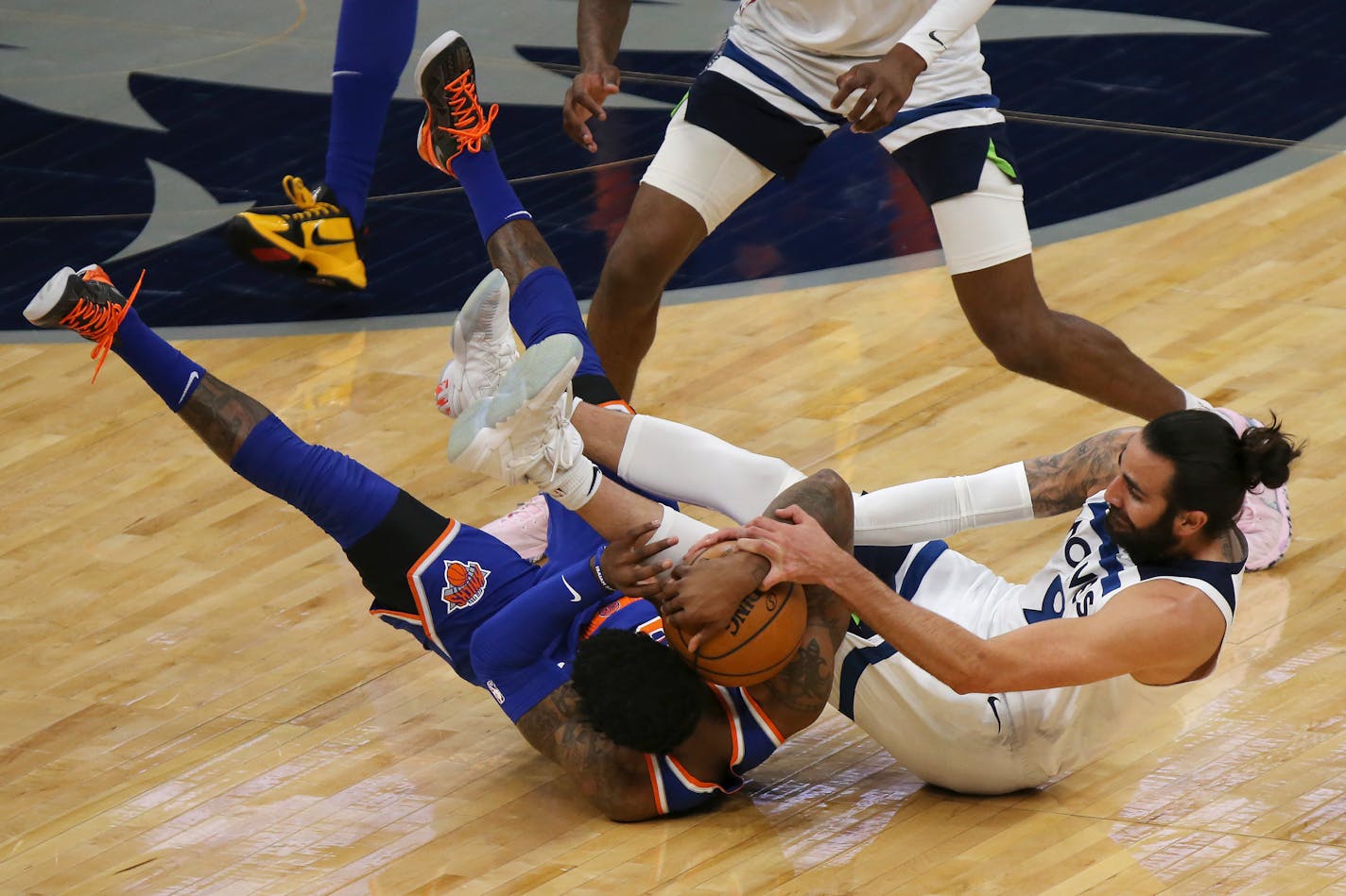 New York Knicks' RJ Barrett, left, and Minnesota Timberwolves' Ricky Rubio (9) scramble for the ball during the first half of an NBA basketball game Wednesday, March 31, 2021, in Minneapolis. (AP Photo/Stacy Bengs)