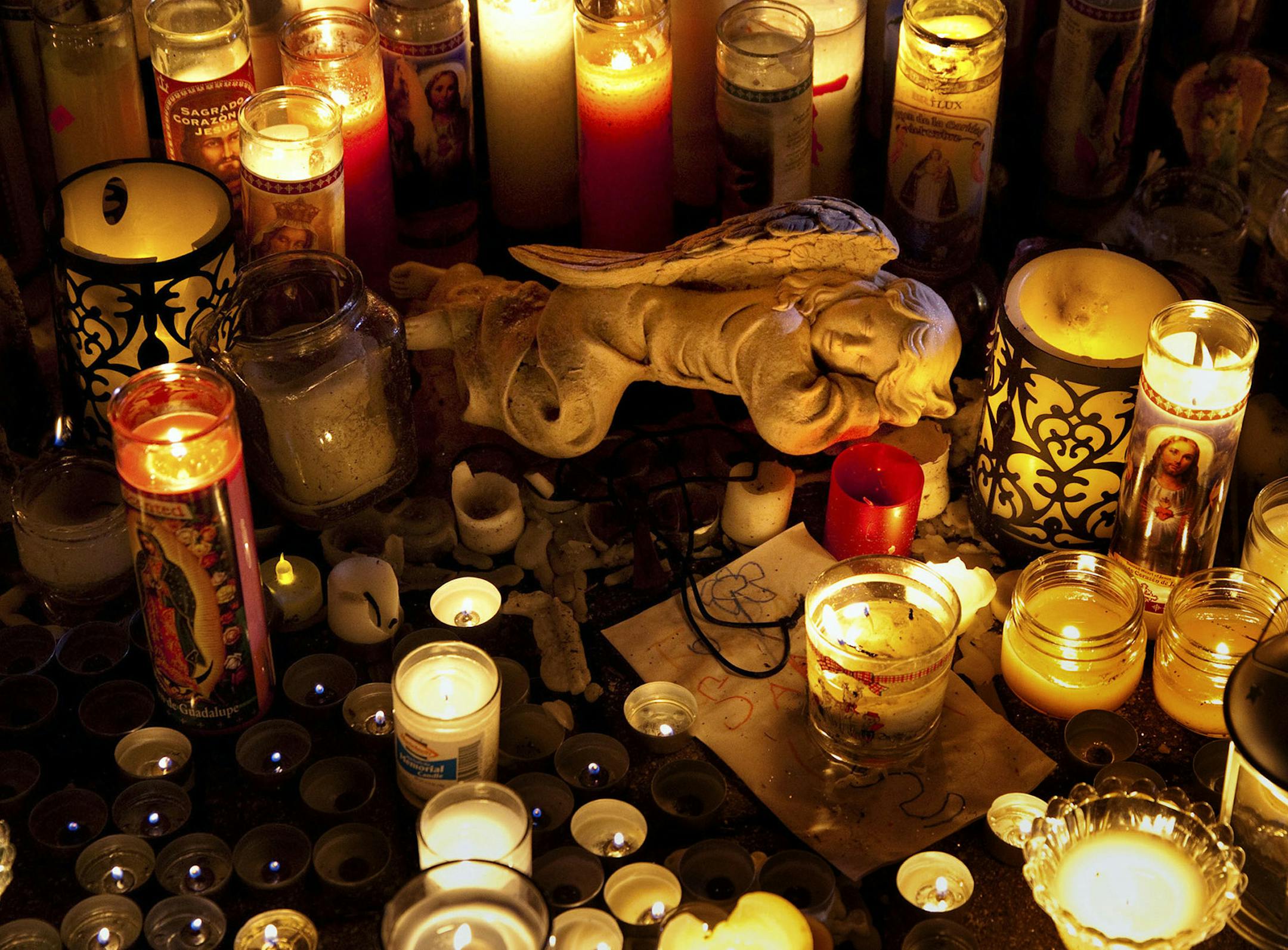 Candles at a makeshift memorial for victims of a shooting at Sandy Hook Elementary School which left 27 people dead, including 20 children, in Newtown, Conn. Dec. 17, 2012. The funerals of two of the victims were held on Monday