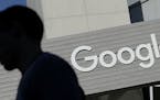 FILE - In this Nov. 12, 2015, file photo, a man walks past a building on the Google campus in Mountain View, Calif. Google is enabling users of its di