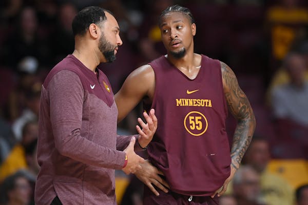 Gophers head coach Ben Johnson spoke to guard Ta’Lon Cooper (55) during Wednesday’s exhibition against St. Olaf