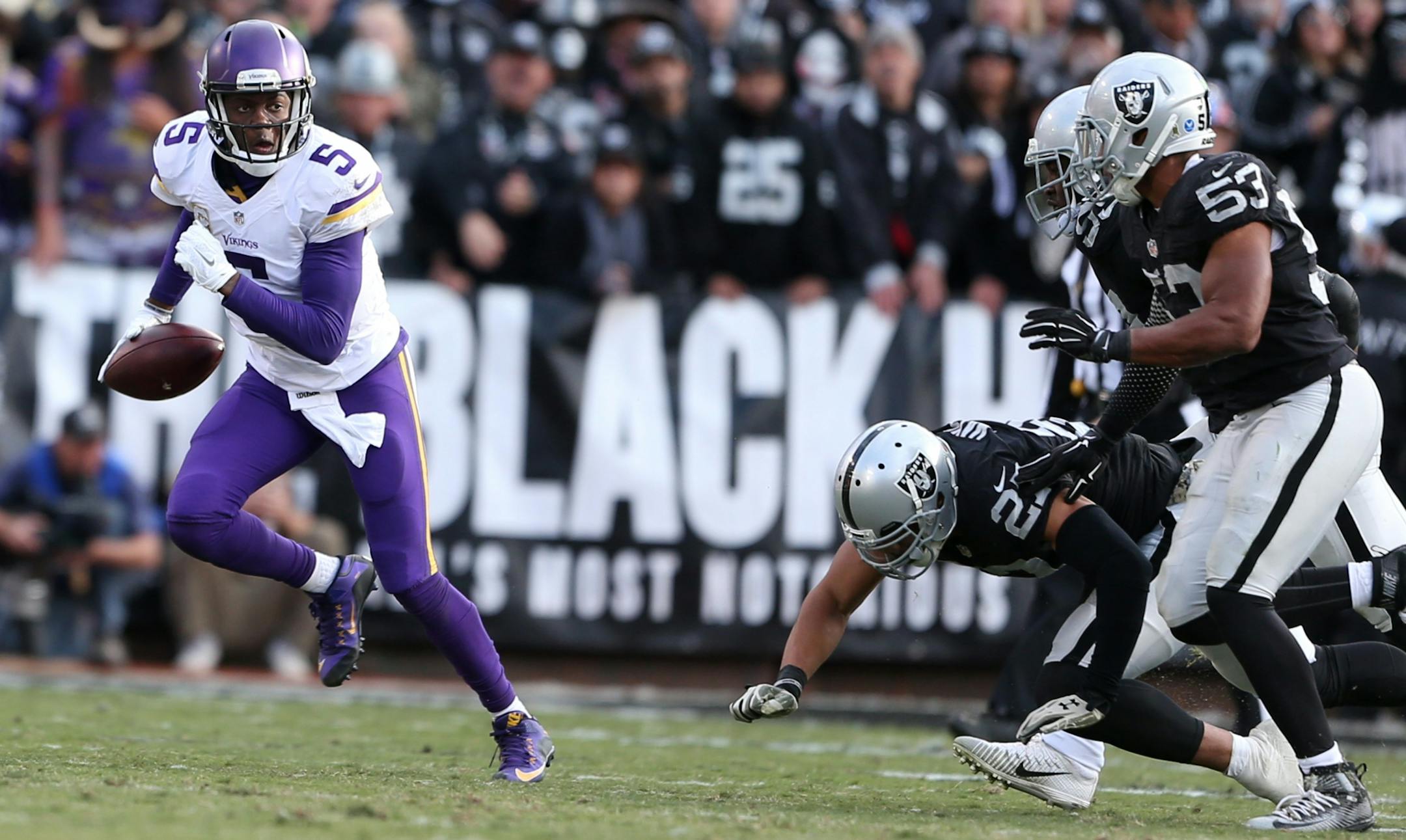 Minnesota Vikings quarterback Teddy Bridgewater (5) avoid the Raiders defenders in the forth quarter at the Oakland Coliseum Sunday November 15, 2015 in Oakland , CA.