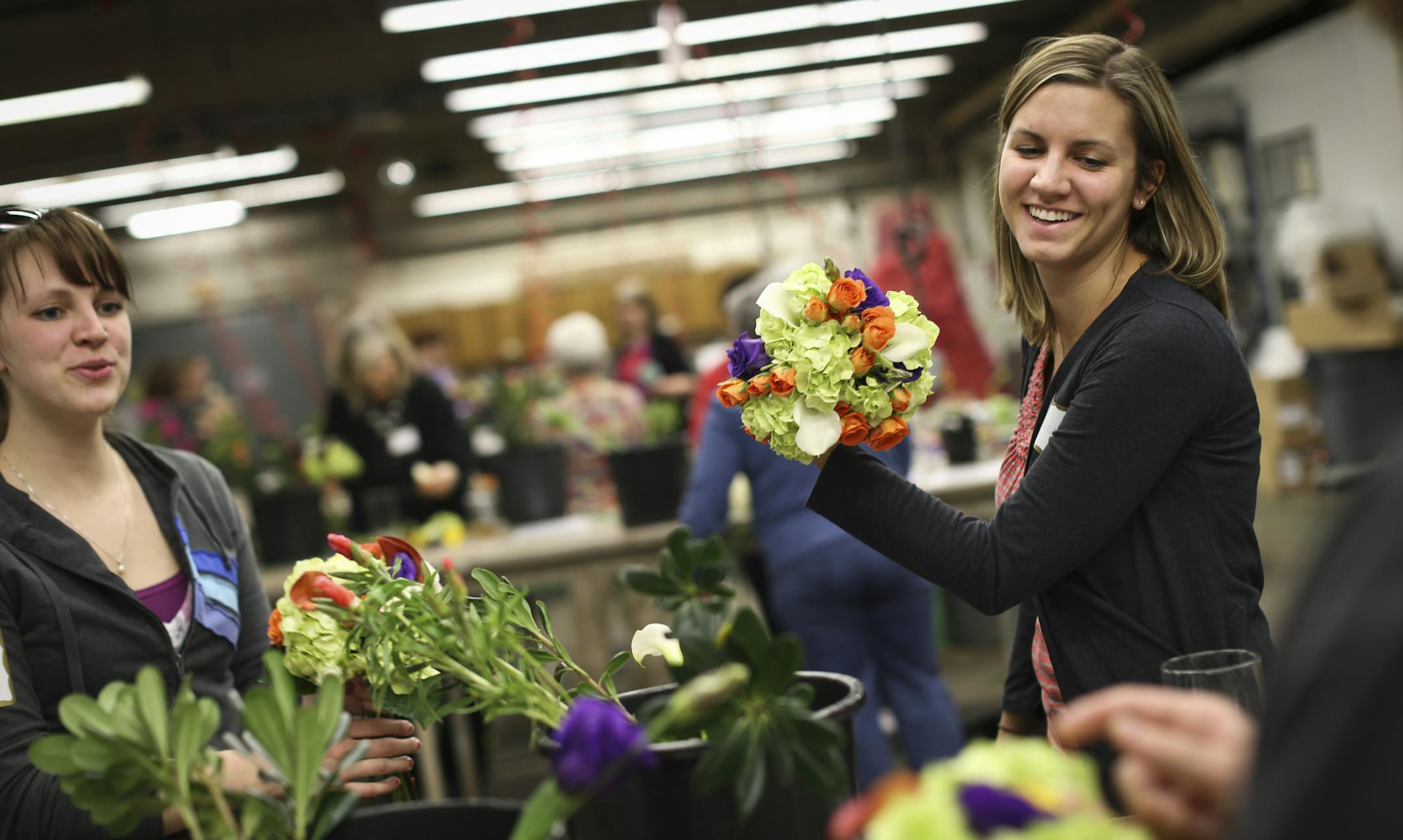 Jessica Dye made a bouquet with her sister, at left, Sarah Dye, during a DIY bridal flower class at Bachman's in Minneapolis, Minn., on Thursday, March 13, 2014. Jessica is getting married in July and hoping to save money on her bridesmaid bouquets by making them herself. ] (RENEE JONES SCHNEIDER &#x2022; reneejones@startribune.com)