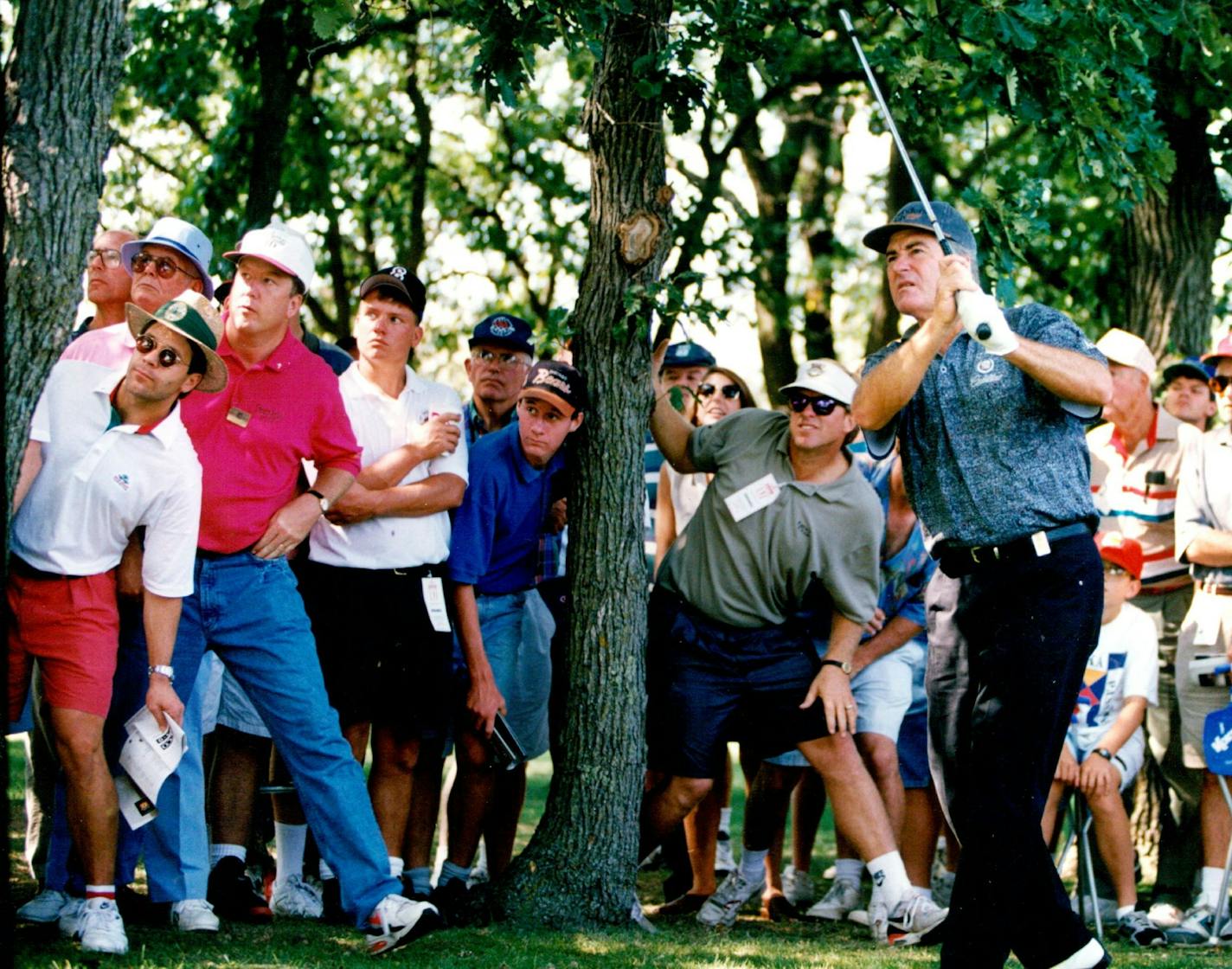 August 21, 1994 Burnet Senior Classic final round. The Crowds watch as Dave Stockton hits a shot through the trees and on the 14th green. Dave Stockton blast out of the sandtrap on the 13th green. Photo 3. Miller Barber reacts after sinking a putt on the 18th green. Photo 4. Jim Albus gets a little tangled up on the 8th green after sinking a putt. Much of the gallery leaned to watch ad Dave Stockton hit his second shot through the trees and onto the 14th green, where he saved par. August 22, 199