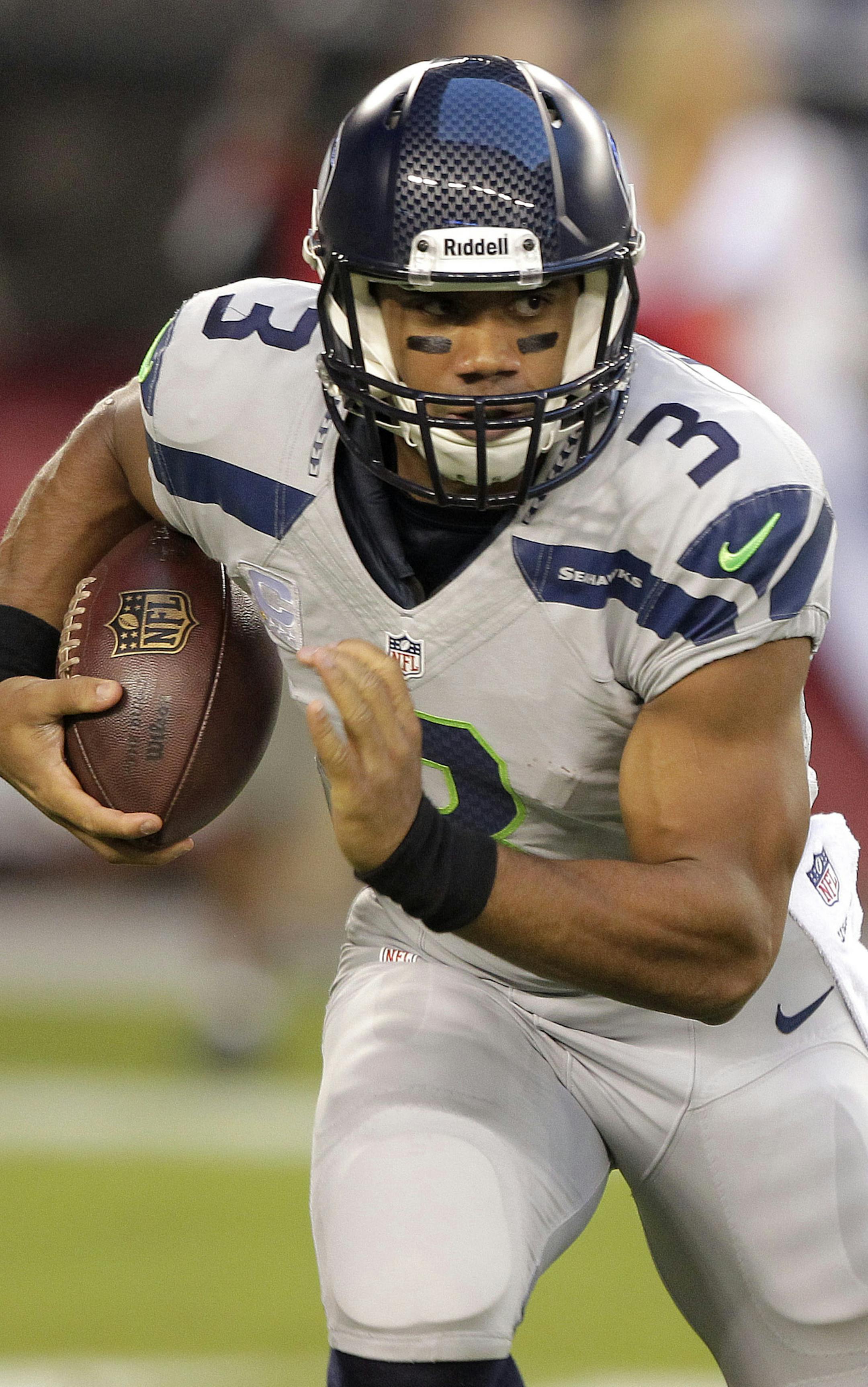 Seattle Seahawks quarterback Russell Wilson runs against the Arizona Cardinals during the first half of an NFL football game, Thursday, Oct. 17, 2013, in Glendale, Ariz. (AP Photo/Rick Scuteri)