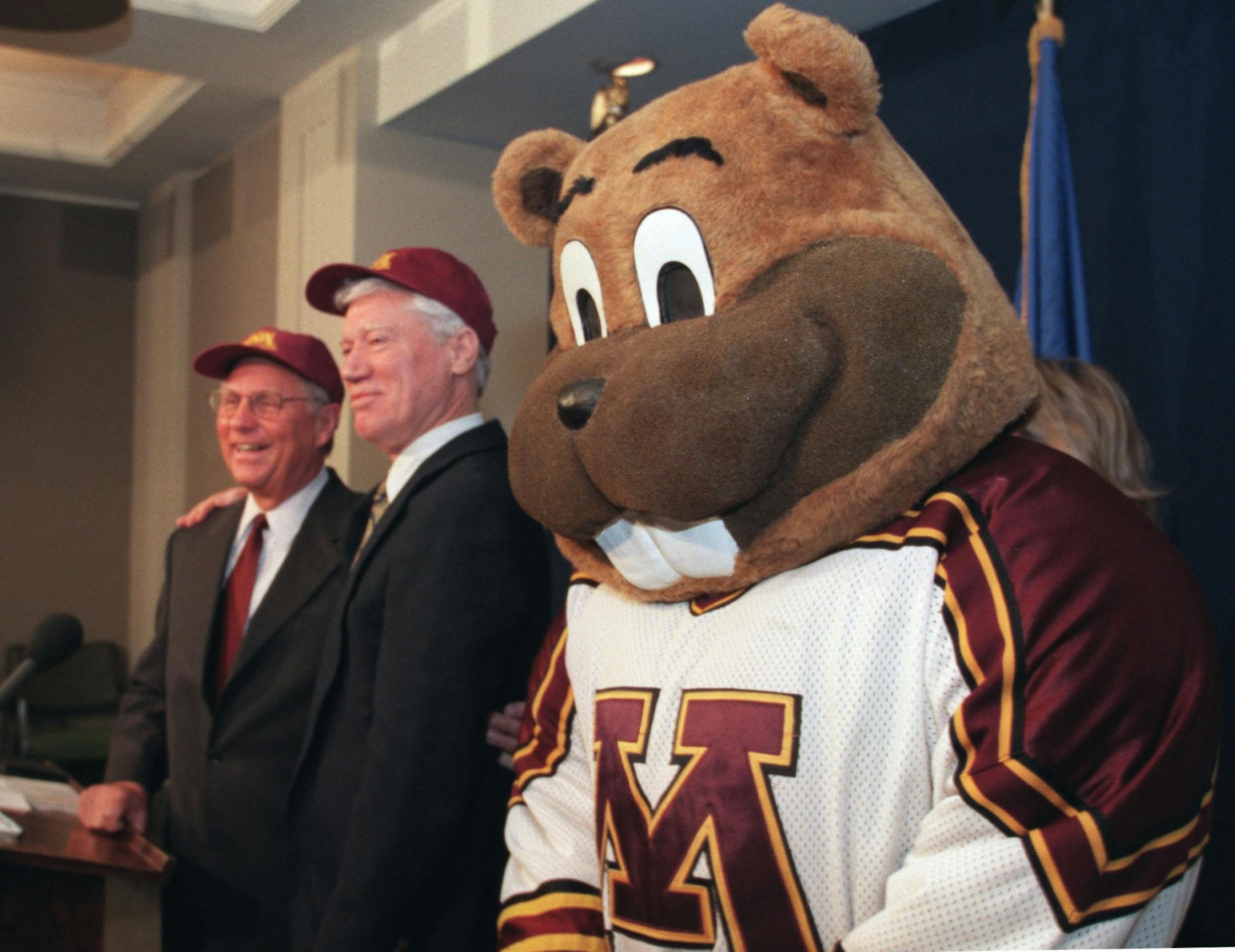 The U's mascot, " Goldie Gopher" stood in for a photo op with the former governors after presenting them with U of M caps. Carlson ( right) and Anderson ( center) said they would tour in support of the university's budget request and that current governor Ventura's proposal was inadequate.