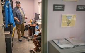 Brian Warden, the Harm Reduction Director at Anything Helps, talks with a client in Minneapolis on Wednesday. Anything Helps is an organization that d
