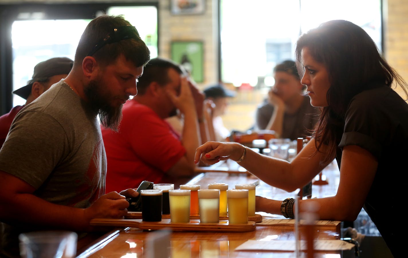 Kelsey Halvorson explained the different types of beer in the flight to Josh Wagner of Bloomington at 612 Brewery.