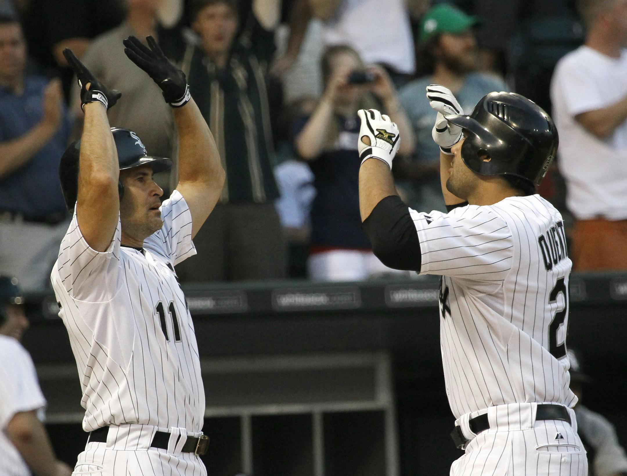 Chicago White Sox's Omar Vizquel, left, greets Carlos Quentin at home plate after the pair scored on Quentin's home run off Seattle Mariners starting pitcher Felix Hernandez during the third inning of a baseball game Tuesday, June 7, 2011 in Chicago. (AP Photo/Charles Rex Arbogast)
