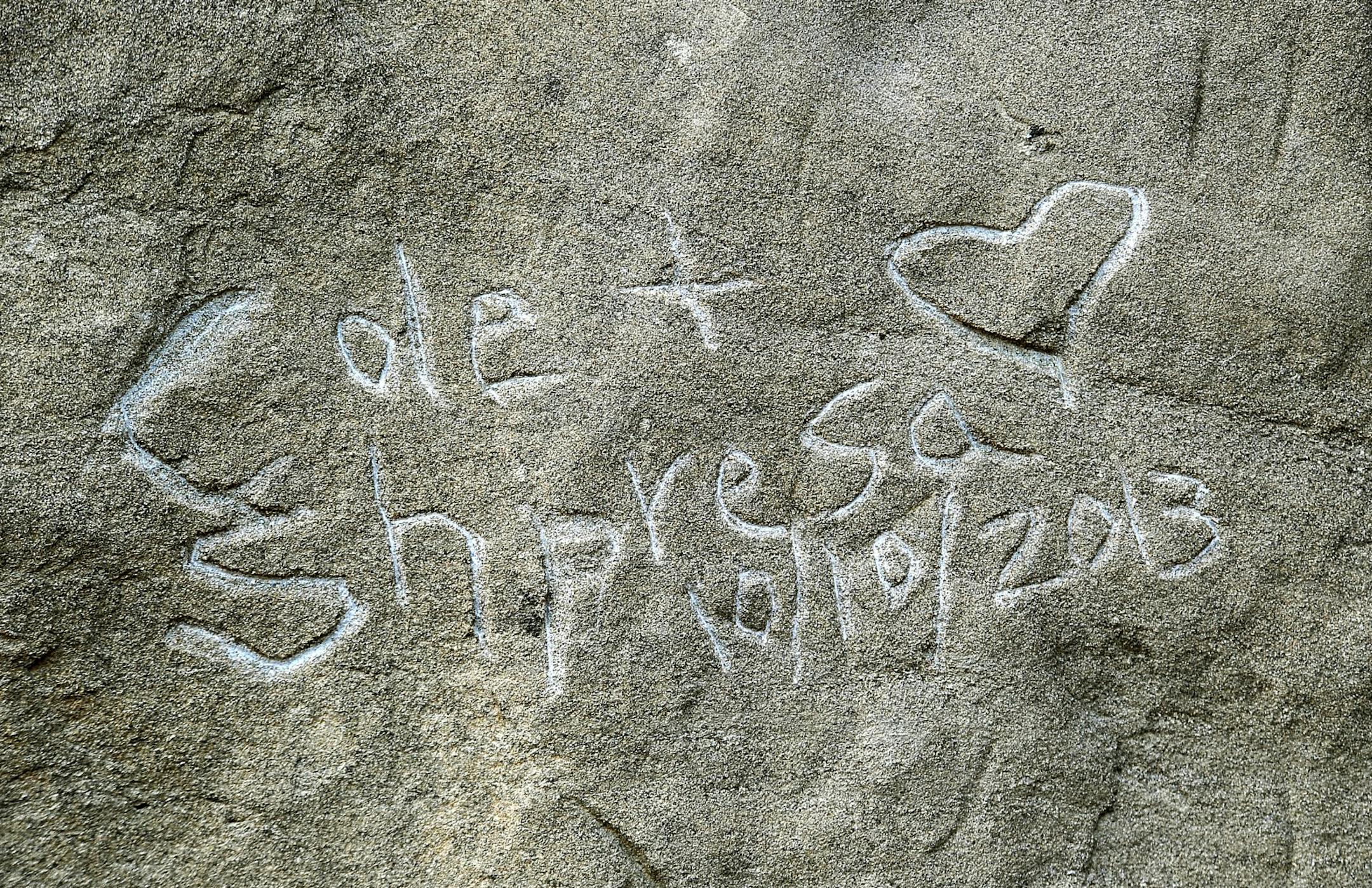 Graffiti spelling "Cole & Shpresa 10/10/2013" is seen carved into the Pompeys Pillar National Monument in Montana.