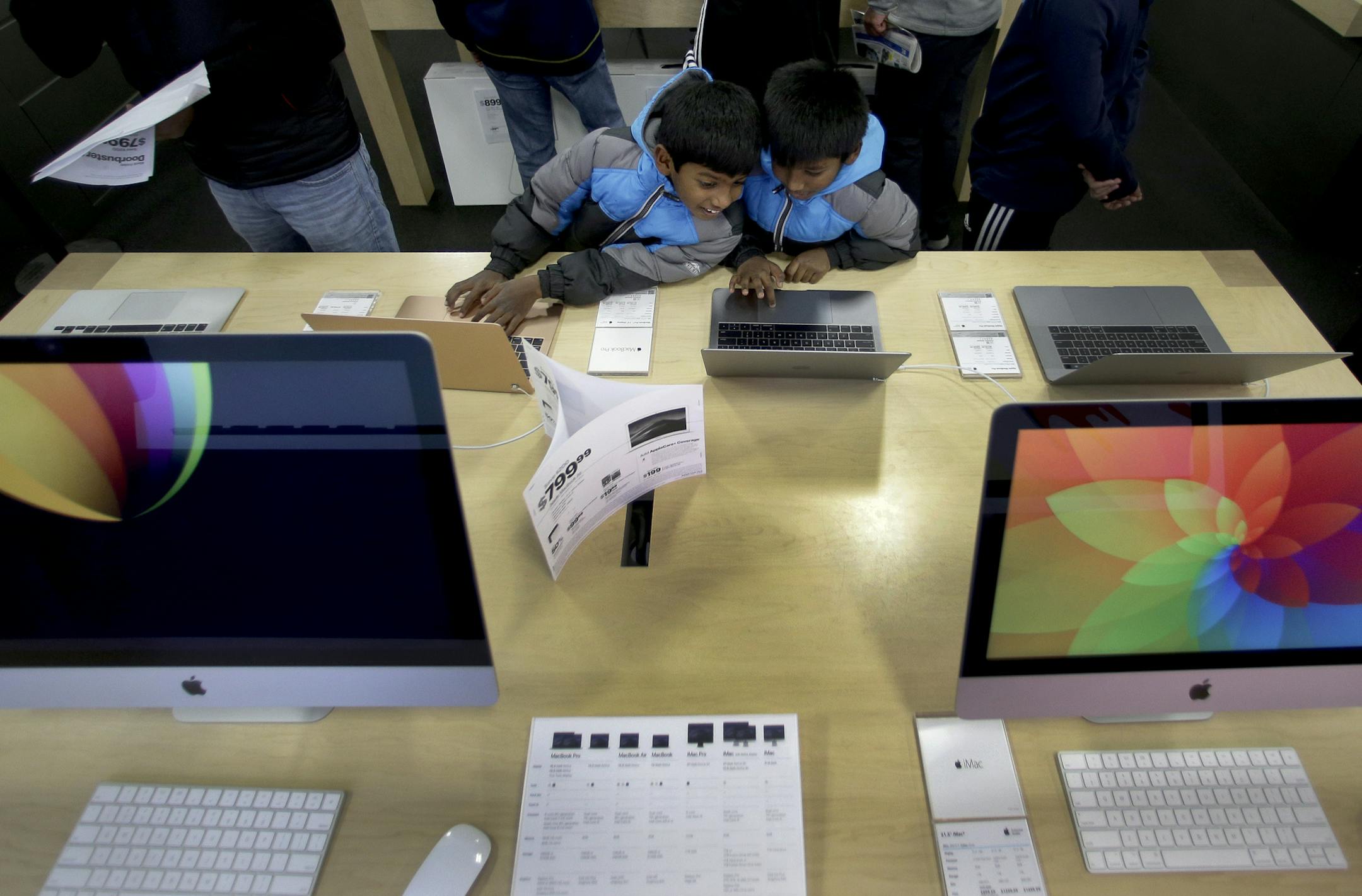 Eight-year-old twins Shalom Justin Kotha, left and Sammy Jayson Kotha, shop Black Friday with their parents at a Kansas City Best Buy store. Consumer electronics are usually big sellers on Cyber Monday. (AP Photo/Charlie Riedel)