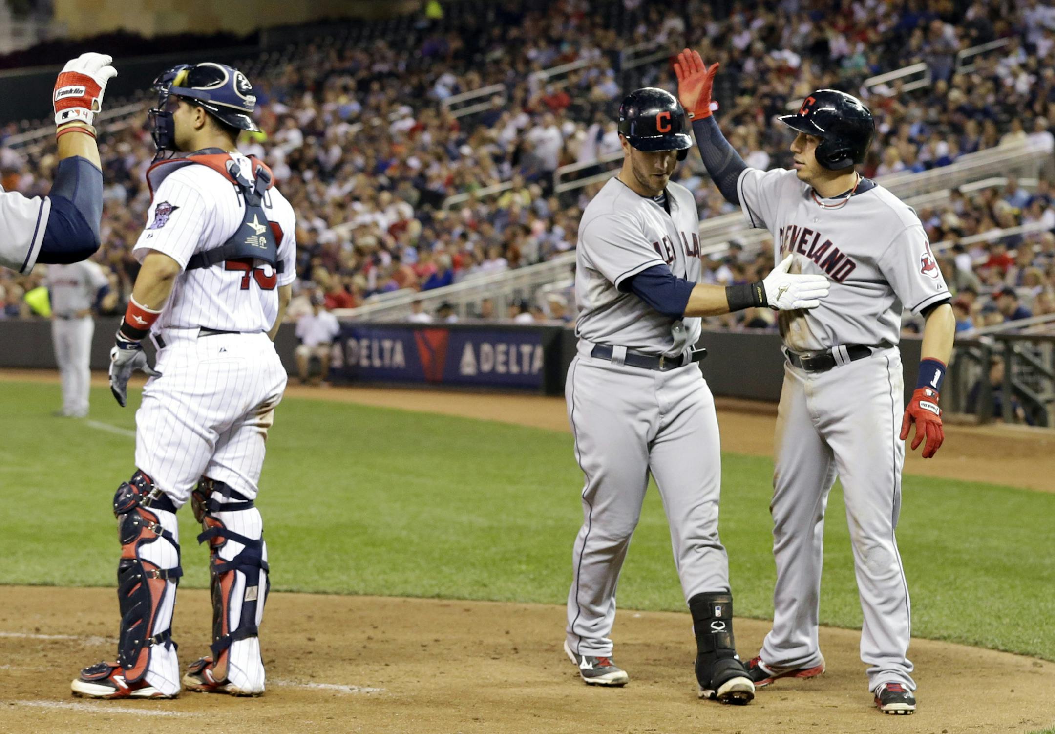 Cleveland Indians' Asdrubal Cabrera, right, congratulates Yan Gomes after Gomes' two-run home run off of Minnesota Twins pitcher Andrew Albers in the fourth inning of a baseball game, Thursday, Sept. 26, 2013, in Minneapolis. (AP Photo/Jim Mone)