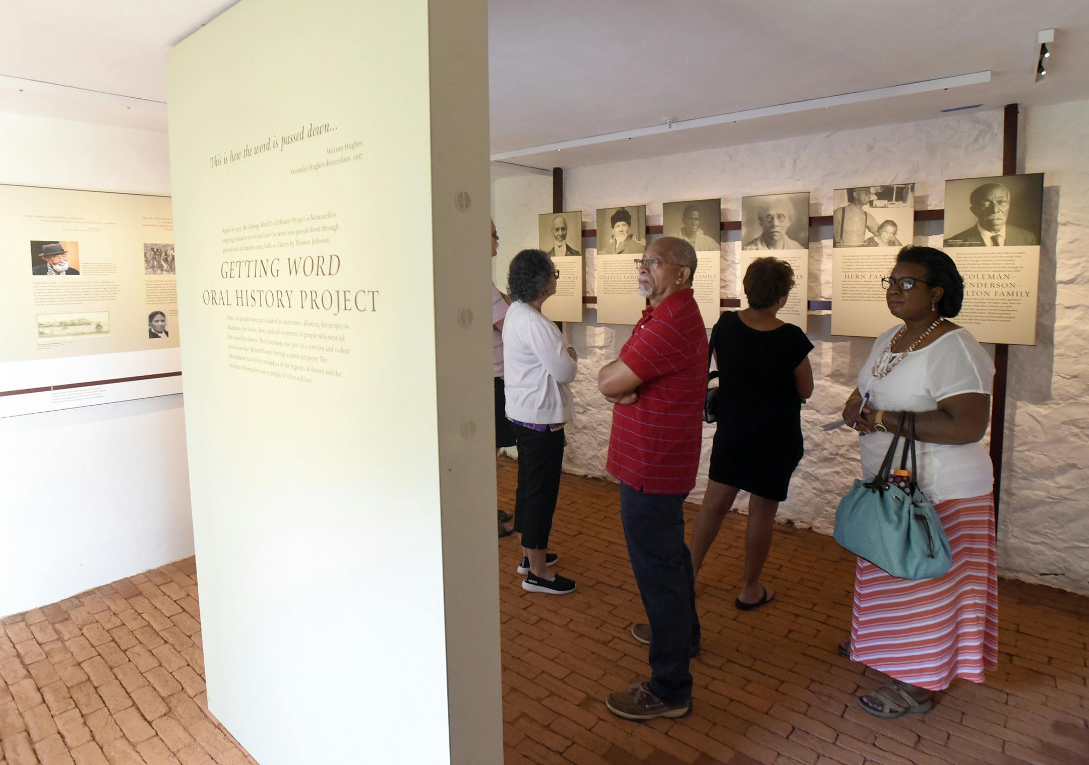 In this photo provided by The Thomas Jefferson Foundation, Bernard Hairston, center, of Charlottesville, Va., looks at an exhibit about Thomas Jefferson's slaves and their descendants during the opening of the South Wing at Monticello, Jefferson's estate in Charlottesville, Va., on Saturday, June 16, 2018. (Steve Ruark/The Thomas Jefferson Foundation via AP)