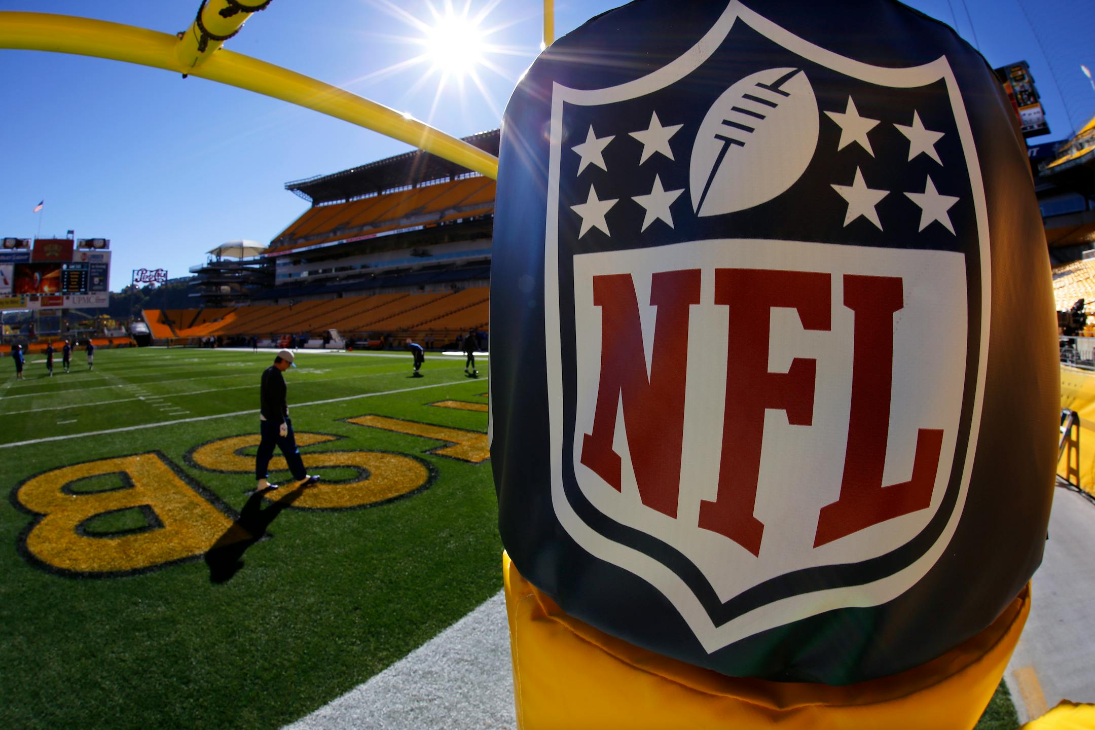 The sun shines over the NFL logo on the goal post before one of the league's games.