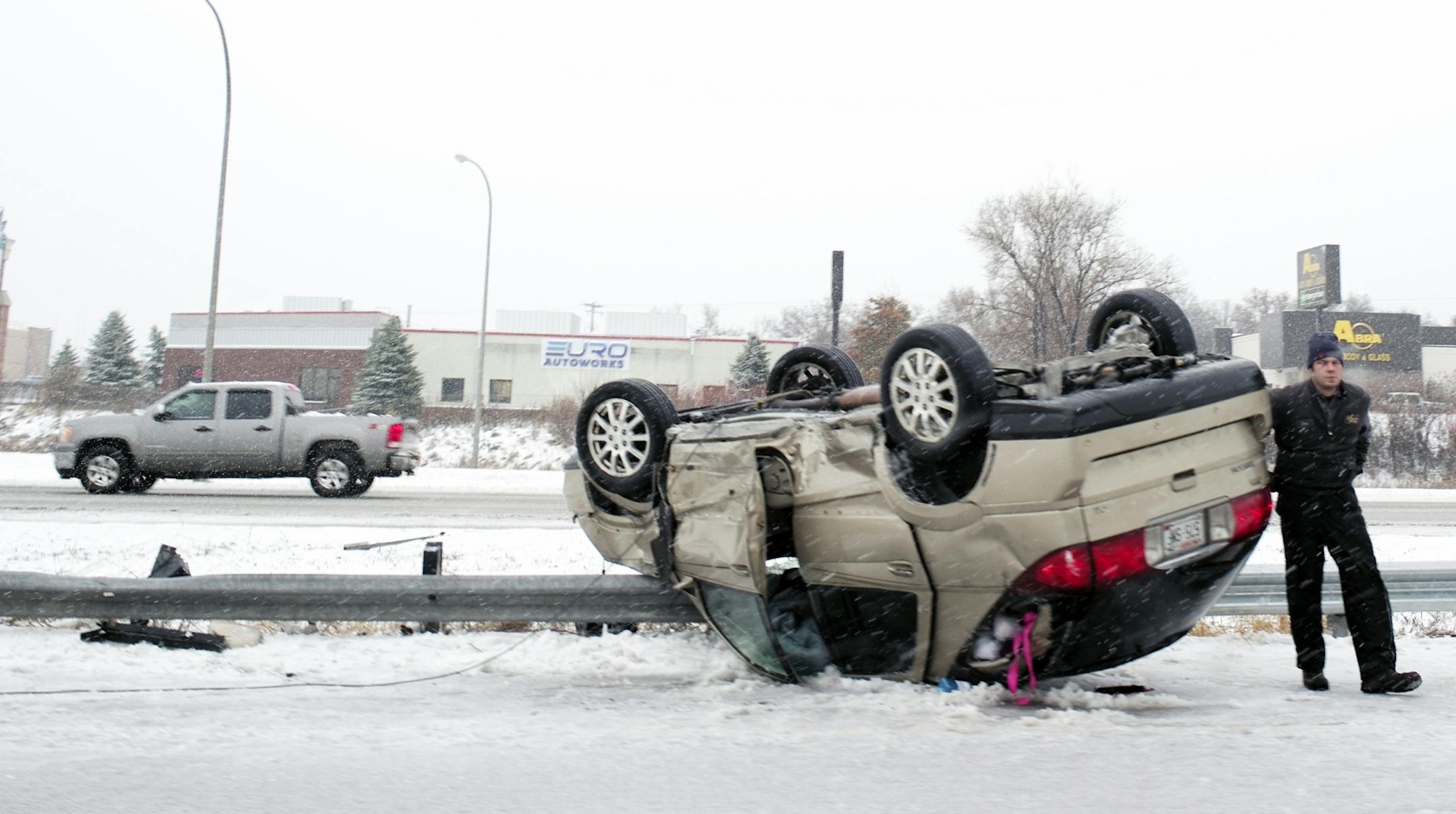 On I94 West on St. Paul near the Radio Ave exit, a tow truck service worker helps remove an overturned vehicle.
