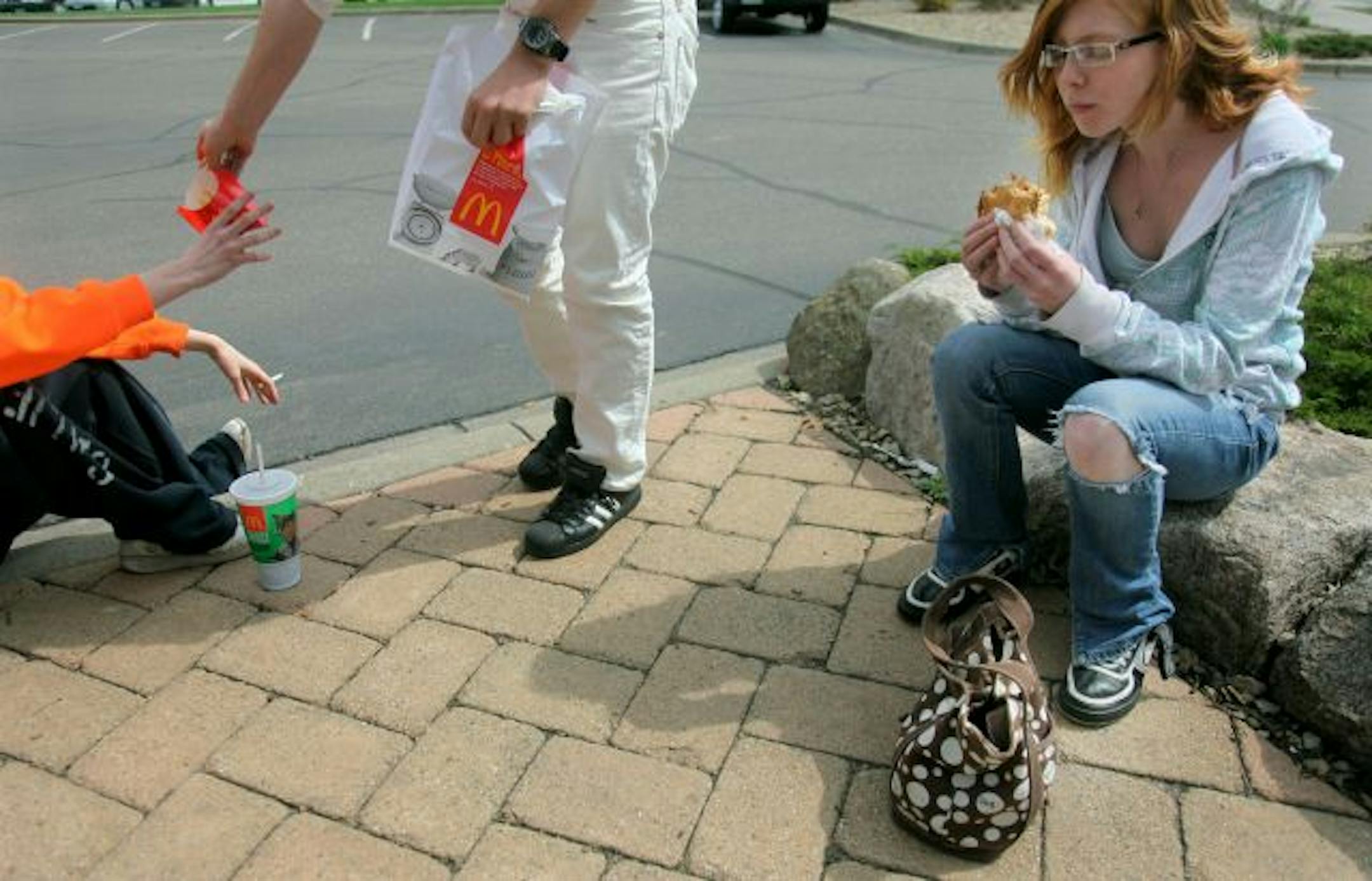 Maria Oldenburg, 18, took her lunch break on a curb near an Anoka County McDonald's restaurant, where she ate leftovers of a friend's lunch. She says she often doesn't eat a full meal until at least 10:30 p.m. at her boyfriend's home