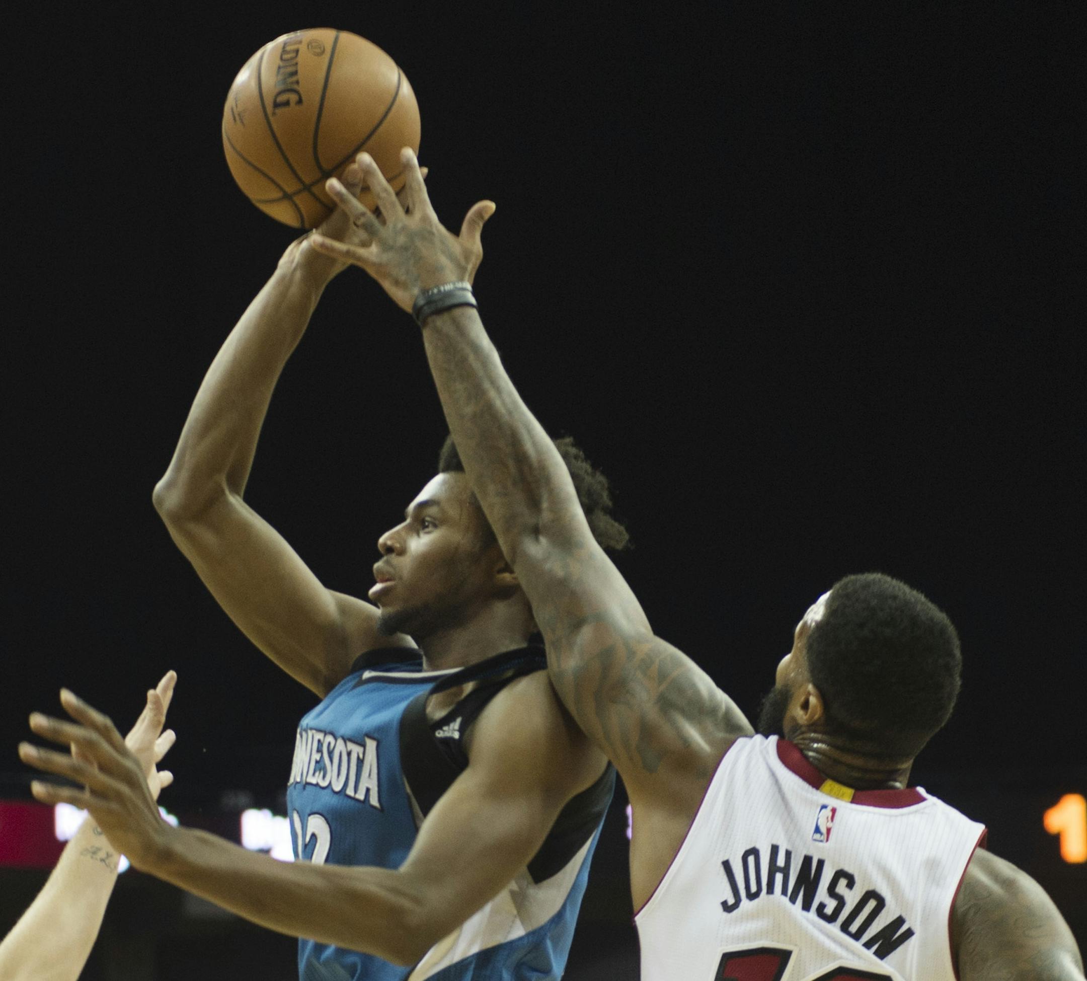 Miami Heat guard Tyler Johnson, left, and forward James Johnson defend Minnesota Timberwolves forward Andrew Wiggins during the first half of a preseason NBA basketball game Saturday, Oct. 8, 2016, in Kansas City, Mo. (Joe Ledford /The Kansas City Star via AP)