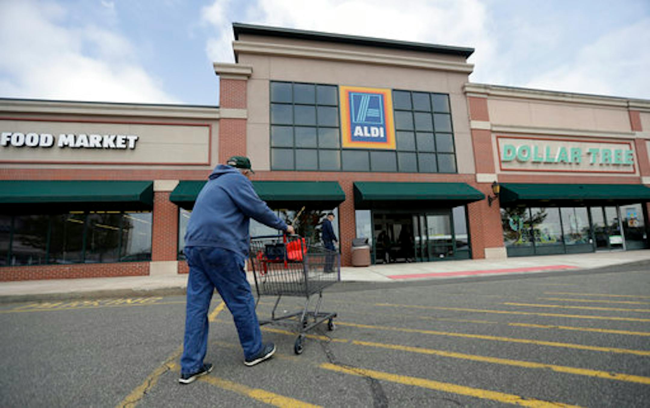 In this Wednesday, May 31, 2017, photo, a customer approaches the entrance of an Aldi food market, in East Rutherford, N.J. Discounter Aldi, one of the no-frills European chains that offer low prices but far fewer options, and mostly its own brands, is putting the pressure on traditional grocers. Aldi expects to have 2,500 U.S. stores by the end of 2022. (AP Photo/Julio Cortez)