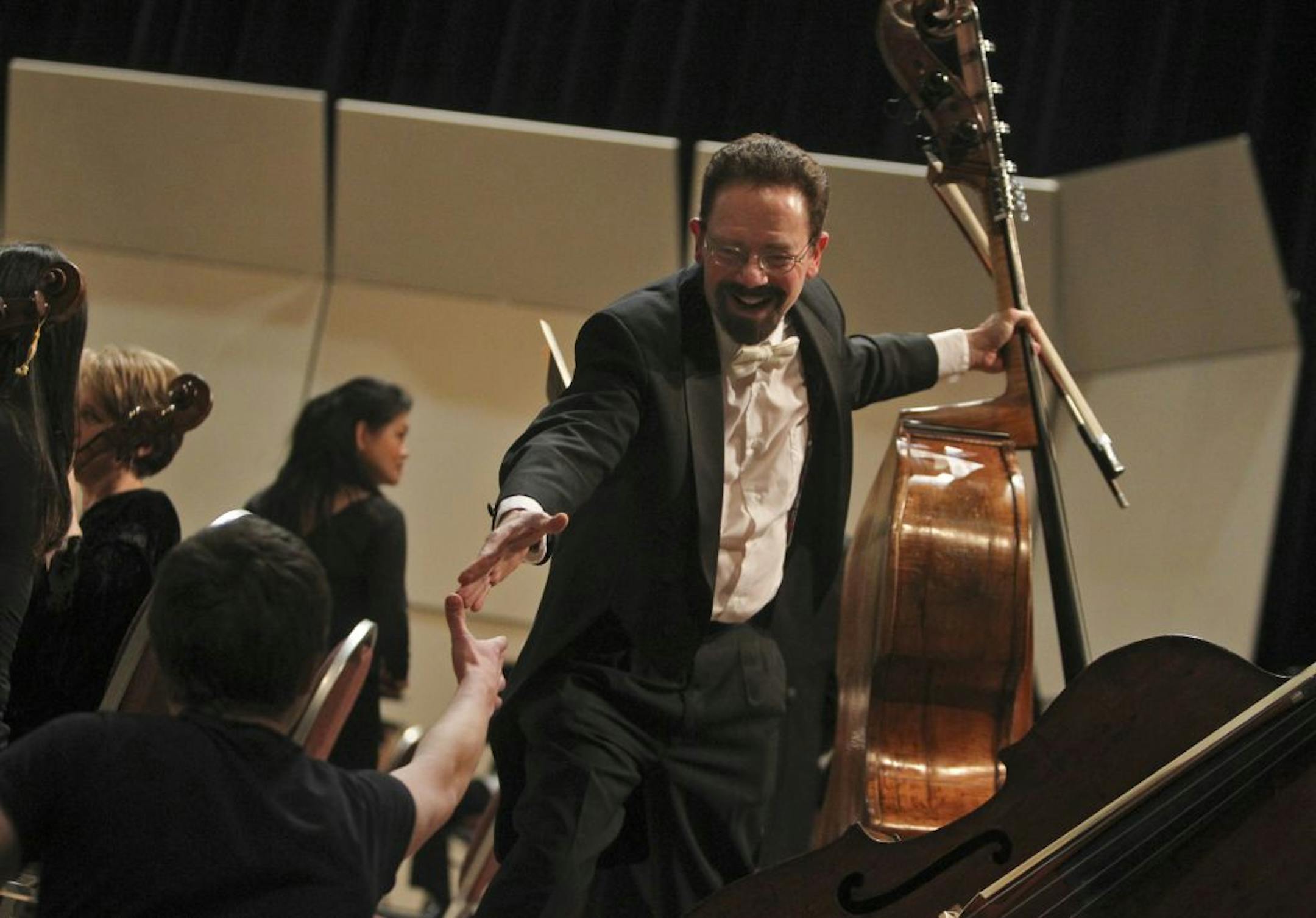 Locked out musicians from the Minnesota Orchestra, led by conductor Osmo Vanska, played a concert at the Minneapolis Convention Center that was proposed by Mayor R. T. Rybak to mark the Grammy nominated CD of music of Sibelius Friday, Feb. 1, 2013, in Minneapolis, MN. Here, bassist William Schrickel reached for the hand of his student Nic Mathisen, 17, of White Bear Lake, and thanked Mathisen for coming to the concert.