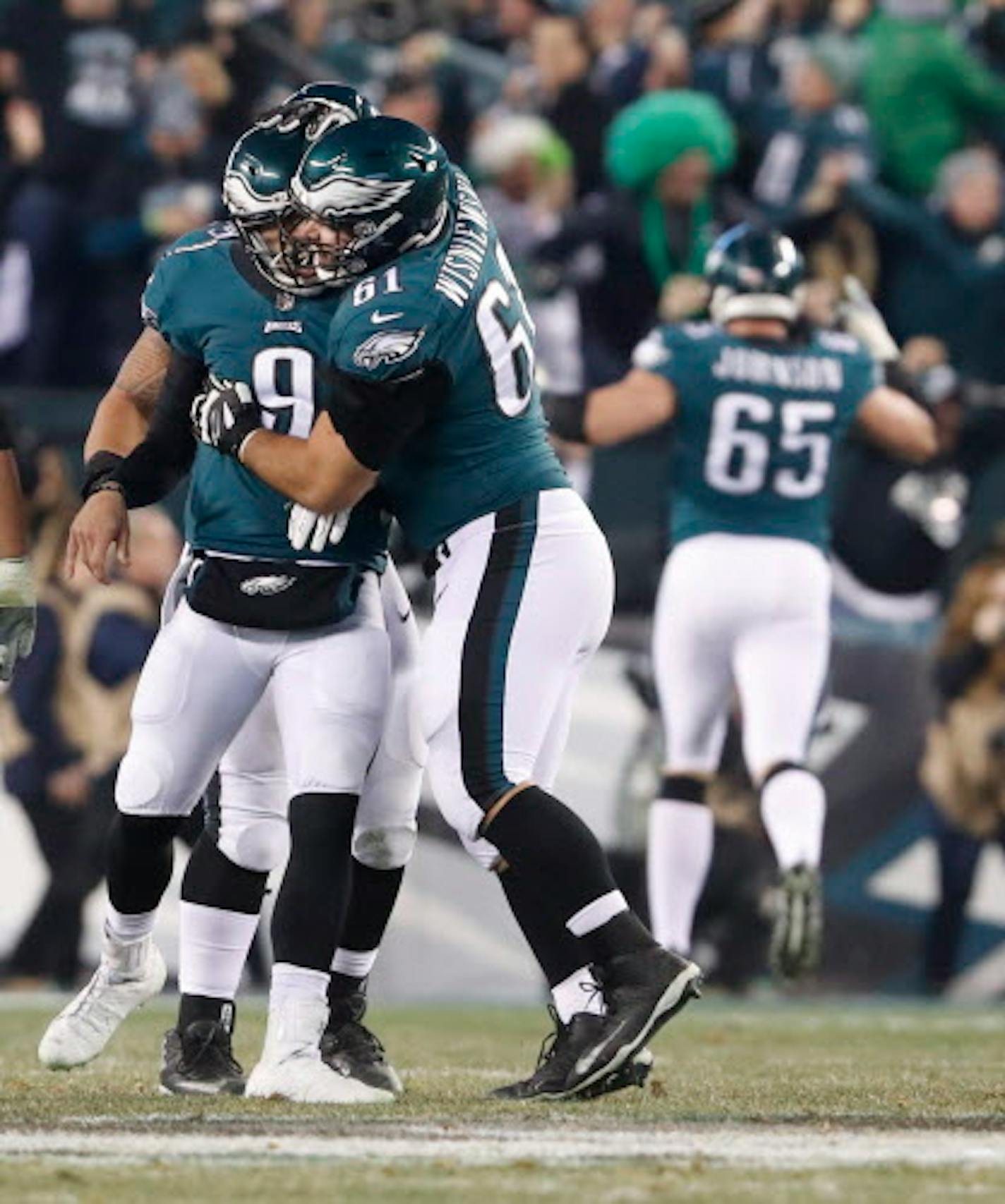 Philadelphia Eagles quarterback Nick Foles (9) celebrated his 53-yard touchdown strike in the second quarter with  offensive lineman Stefen Wisniewski (61). The Eagles led 24-7 at halftime.