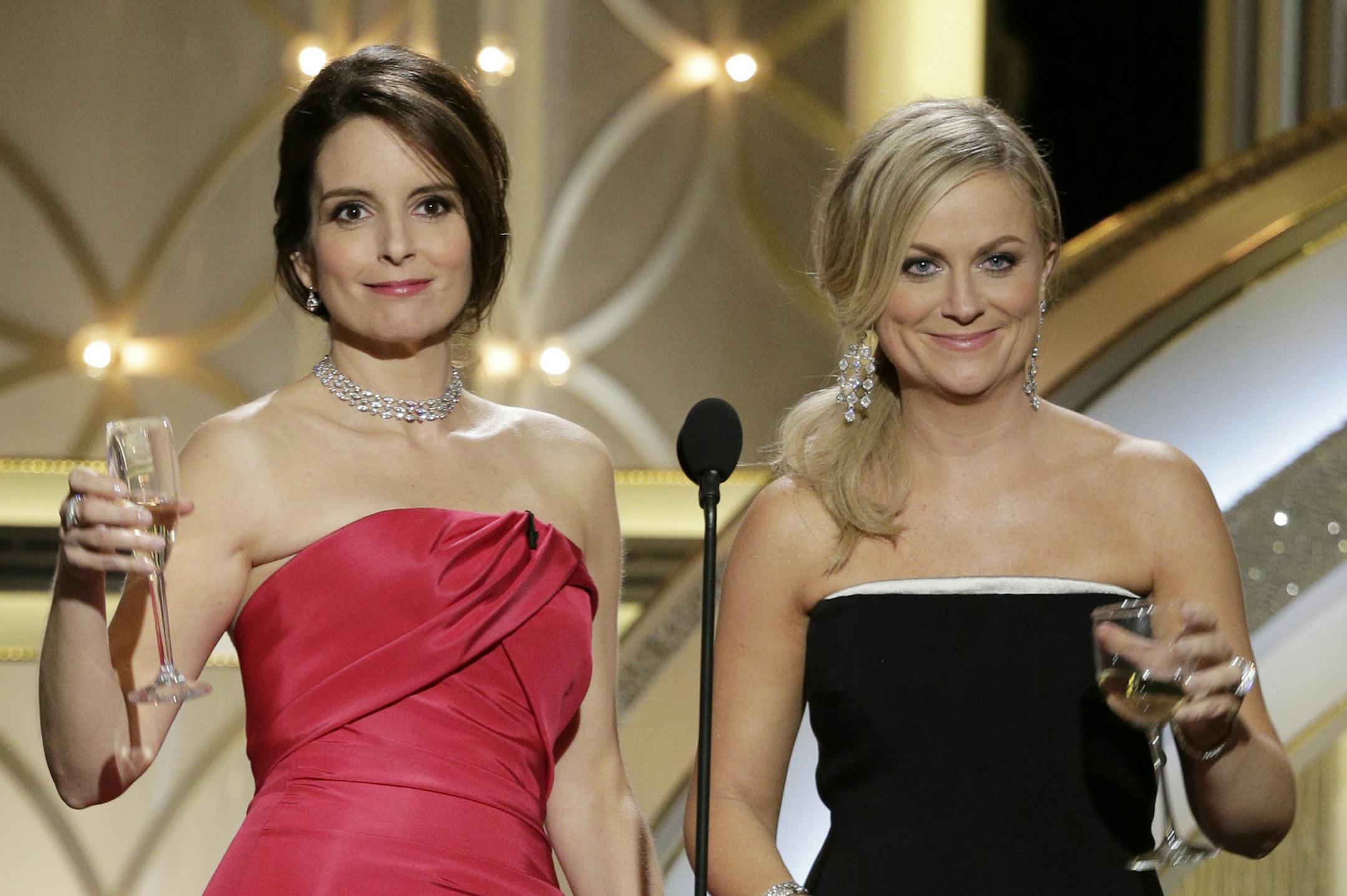 This image released by NBC shows hosts Tina Fey, left, and Amy Poehler during the 71st annual Golden Globe Awards at the Beverly Hilton Hotel on Sunday, Jan. 12, 2014, in Beverly Hills, Calif. (AP Photo/NBC, Paul Drinkwater) ORG XMIT: MIN2014011309270021