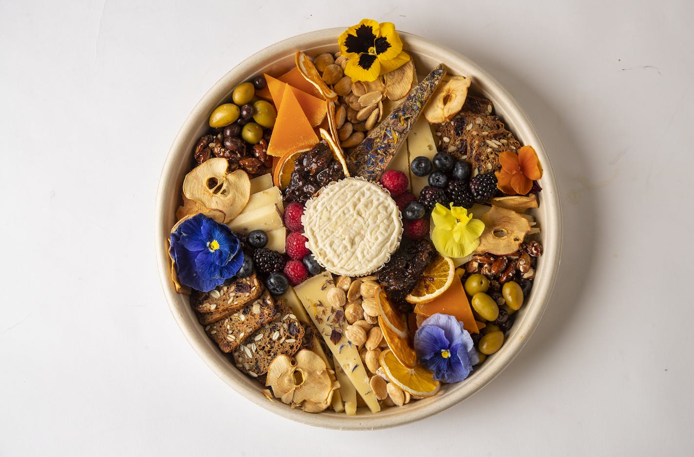 A mix of cheese, bread, olives, nuts and dried fruit and edible flowers from Gazta & Enhancements.