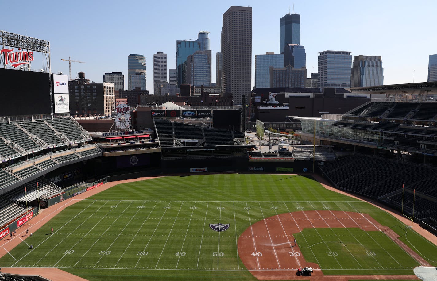 Groundskeepers worked to transform Target Field from a baseball to a football configuration in preparation for Saturday's game between St. Thomas and St. John's.