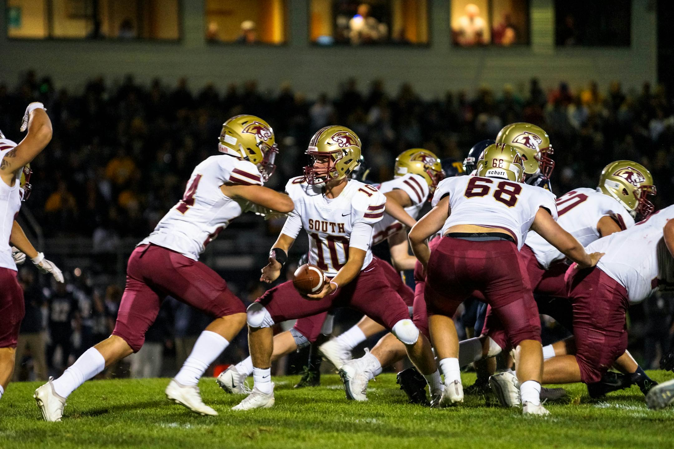 Quarterback Reid Patterson hands off the ball in the Cougars' season-opening game Aug. 29 against Totino-Grace. Photo by Korey McDermott, SportsEngine