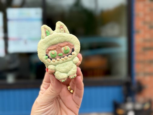 A green Labubu macaron outside X2 Pastries bakery