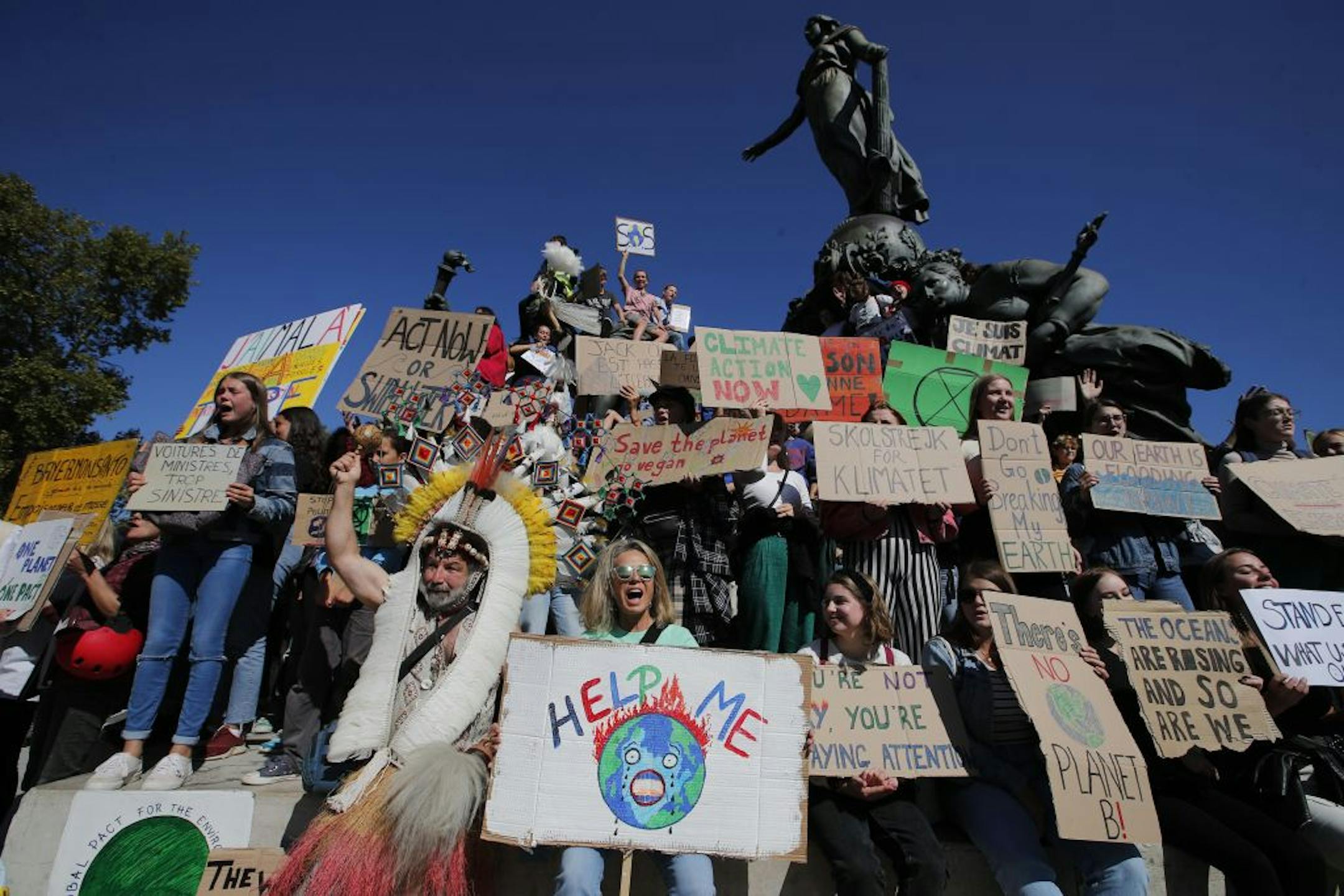 Youths gather at Nation square at the start of a climate demonstration Friday, Sept. 20, 2019 in Paris. In Canberra and Kabul, Cape Town and Berlin, and across the globe, hundreds of thousands of people took the streets Friday to demand that leaders tackle climate change in the run-up to a U.N. summit.