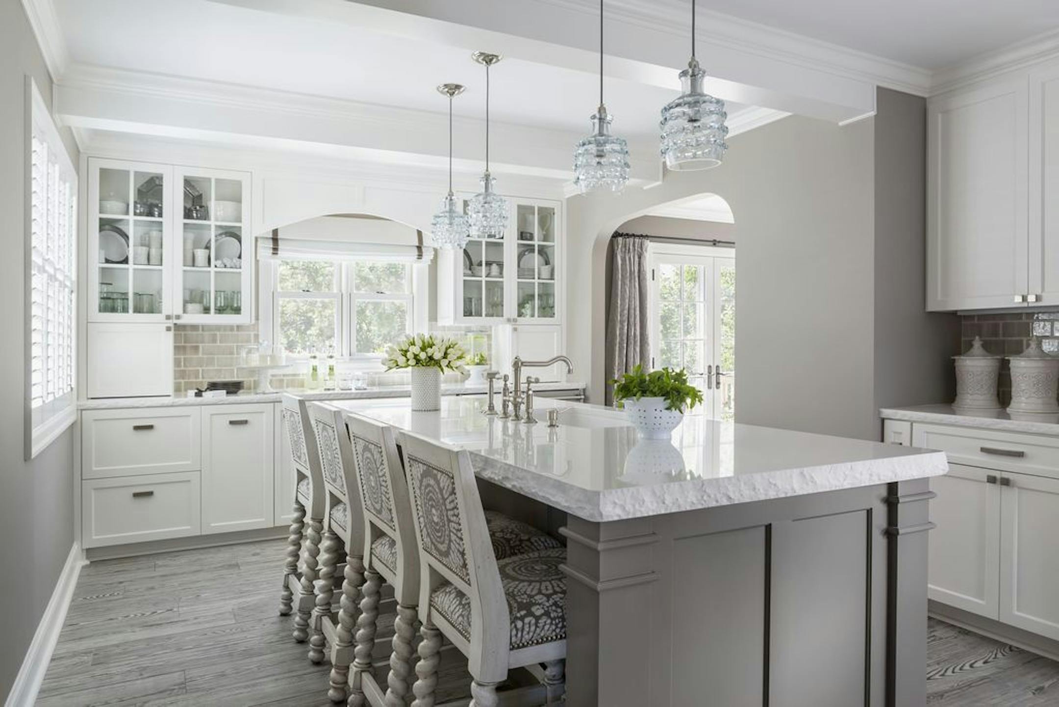 The white quartz-topped island for casual dining feels fresh and distinctive, thanks to the chunky chiseled edge on the counters and island top.