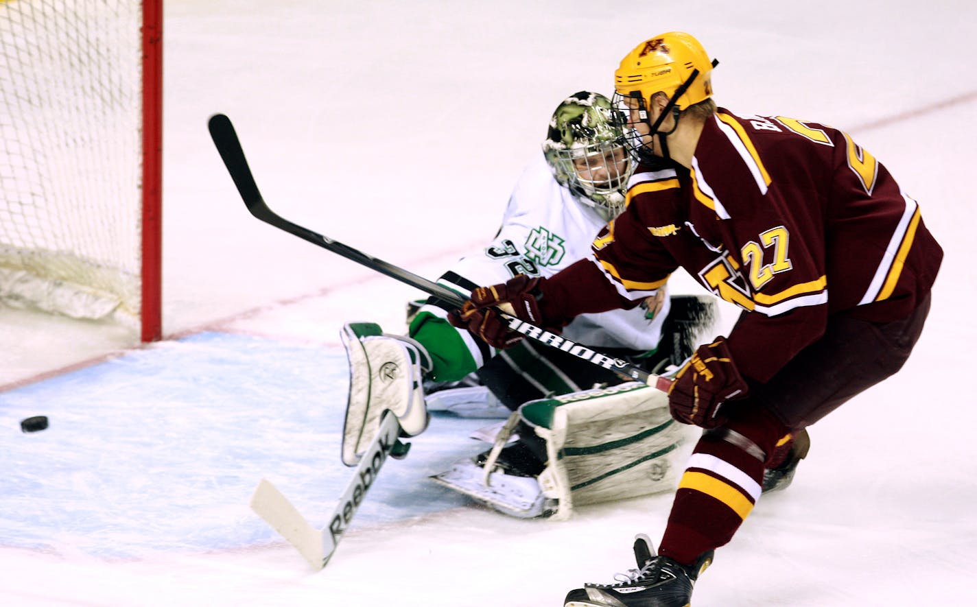 Minnesota's Nick Bjugstad (27) scores past North Dakota goalie Aaron Dell in the first period of an NCAA college hockey game, Saturday, Jan. 14, 2012, in Grand Forks, N.D. Bjugstad scored twice in the first period as Minnesota won 6-2. (AP Photo/The Grand Forks Herald, John Stennes)