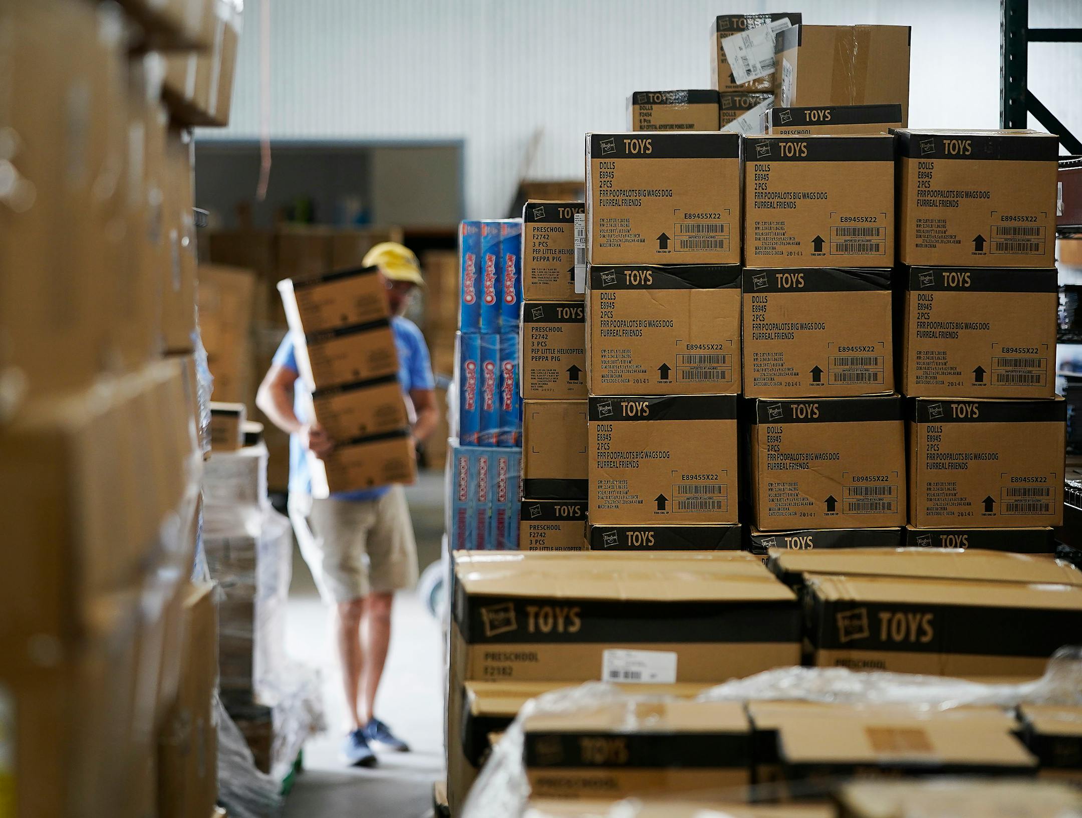 Reid Hegland, warehouse associate at Legacy Toys distribution center, moved boxes of Hasbro toys from a pallet.
