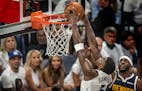 Wolves guard Anthony Edwards dunks over Nuggets forward Justin Holiday during the third quarter of Game 4 Sunday night. With the Wolves struggling for