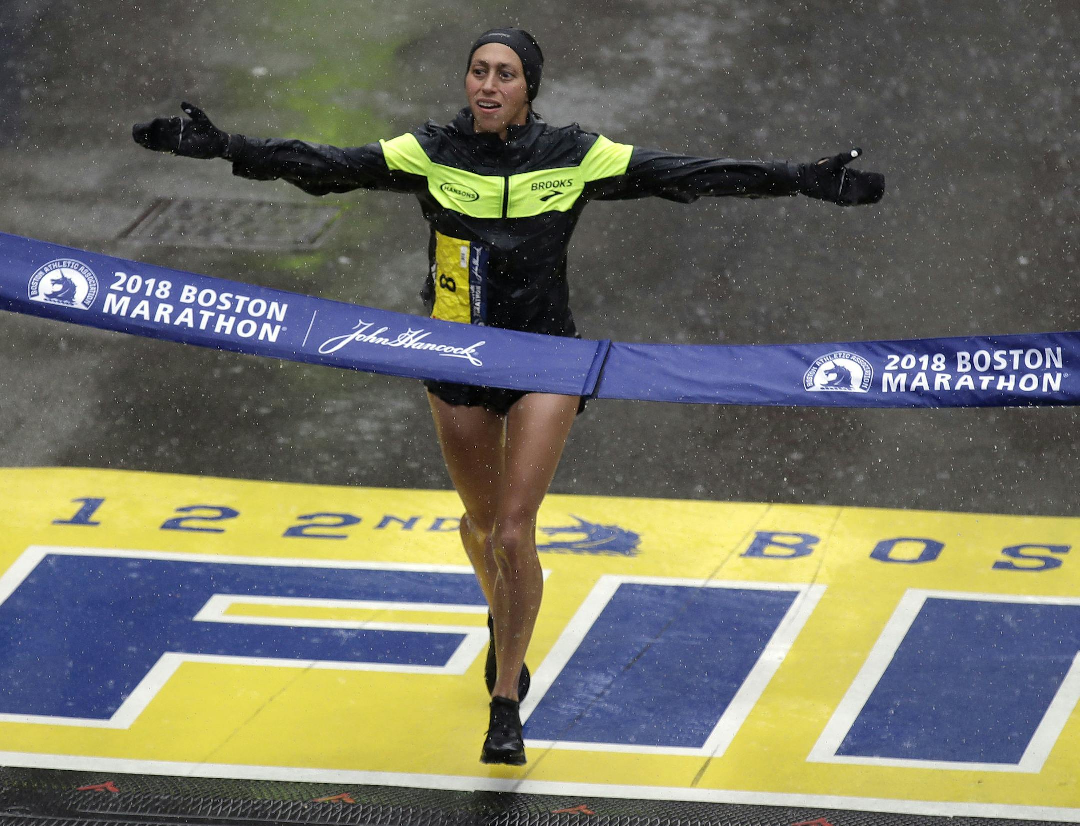 FILE- In this April 16, 2018, file photo, Desiree Linden, of Washington, Mich., crosses the finish line to win the women's division of the 122nd Boston Marathon in Boston. Footwear will be a the forefront at the U.S. Olympic marathon trials this weekend in Atlanta. No matter what time the marathoners turn in or how well they run, the they know their shoes will be the real headliner. (AP Photo/Charles Krupa, File)