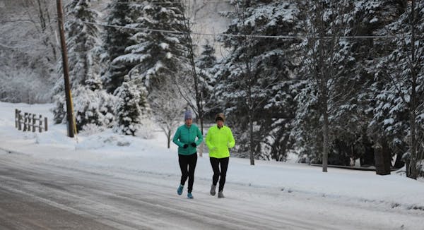The Metro are got between 4 to 6 inches of snow. Suzy Eastman and Elise Kingman both from Wayzata , ran along a snow cover road in Wayzata Minn.