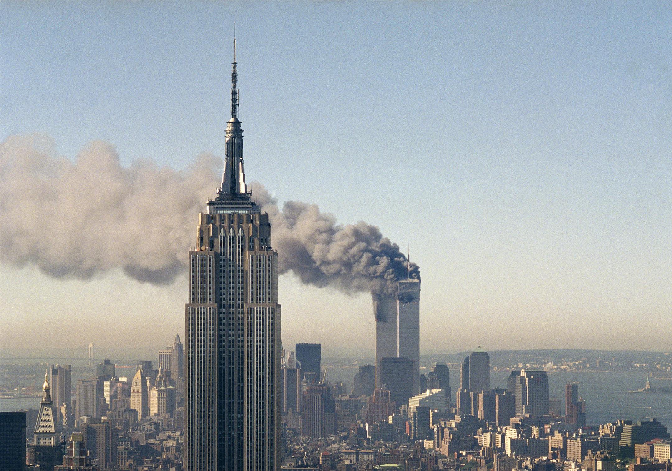 In this Sept. 11, 2001 file photo the twin towers of the World Trade Center burn behind the Empire State Building in New York after terrorists crashed two planes into the towers causing both to collapse.